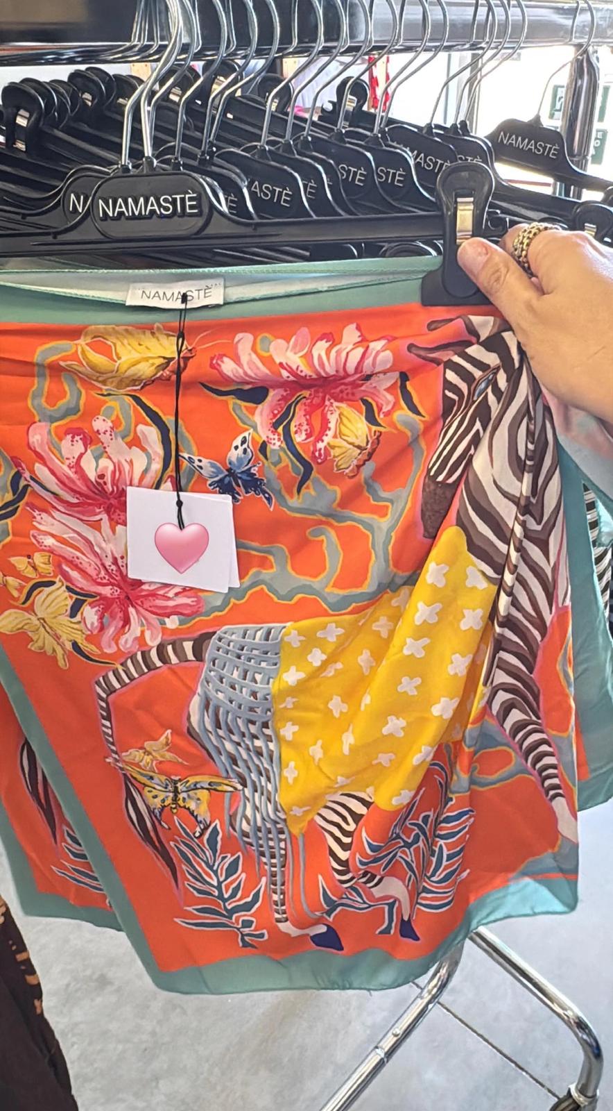 Pareo mini Namaste fondo arancio con fenicottero zebrato, fiori tropicali, farfalle multicolore e bordo verde acqua