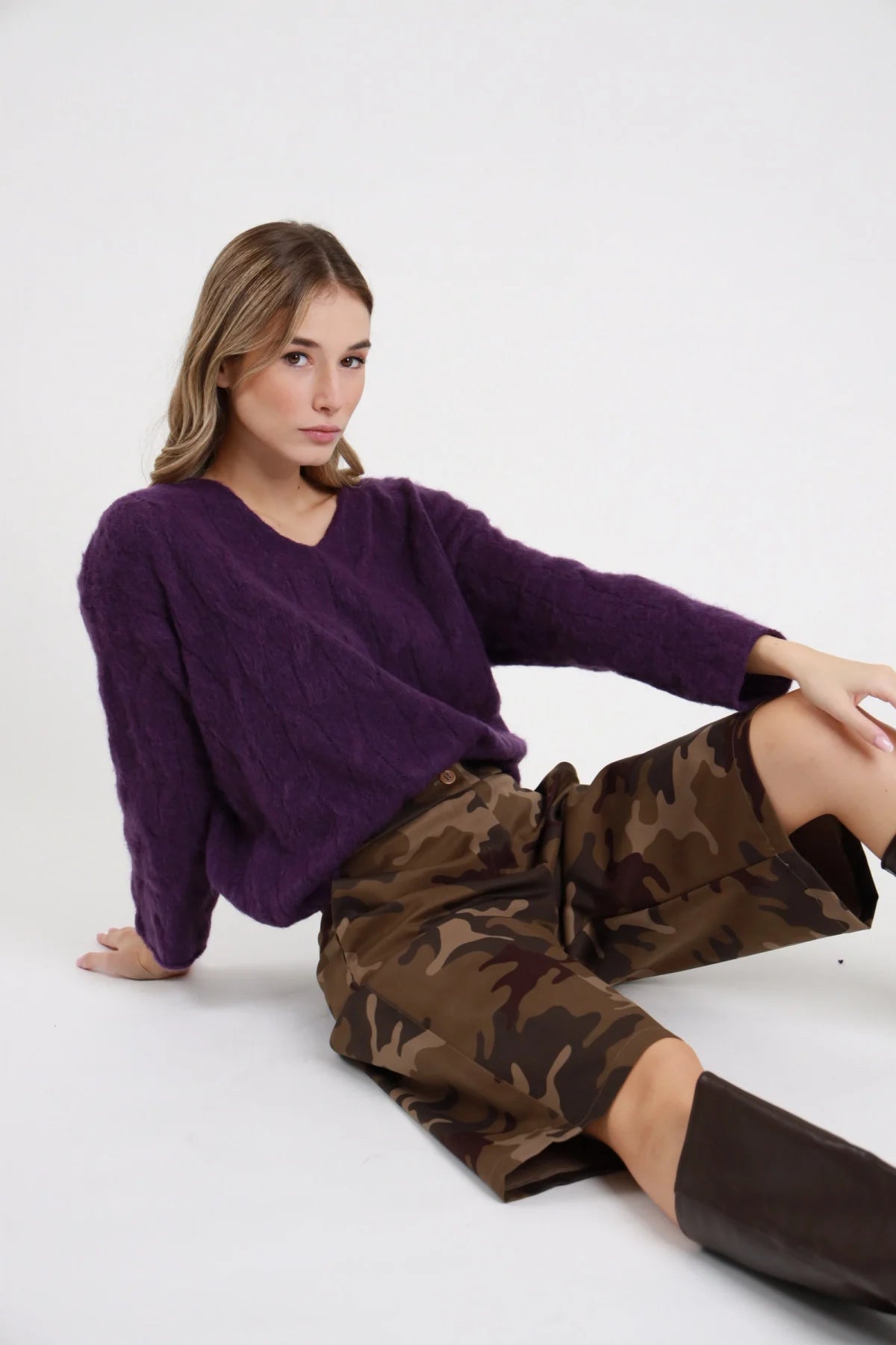 Bermuda camouflage Susy Mix Pre-Fall stampa mimetica militare vita alta bottone singolo visibile gamba larga wide lunghezza ginocchio seduta pavimento 3/4 laterale - modella seduta pavimento 3/4 laterale capelli biondi mossi sfondo bianco bottone vita dettaglio maglione viola trecce stivali cuissardes marrone abbinati