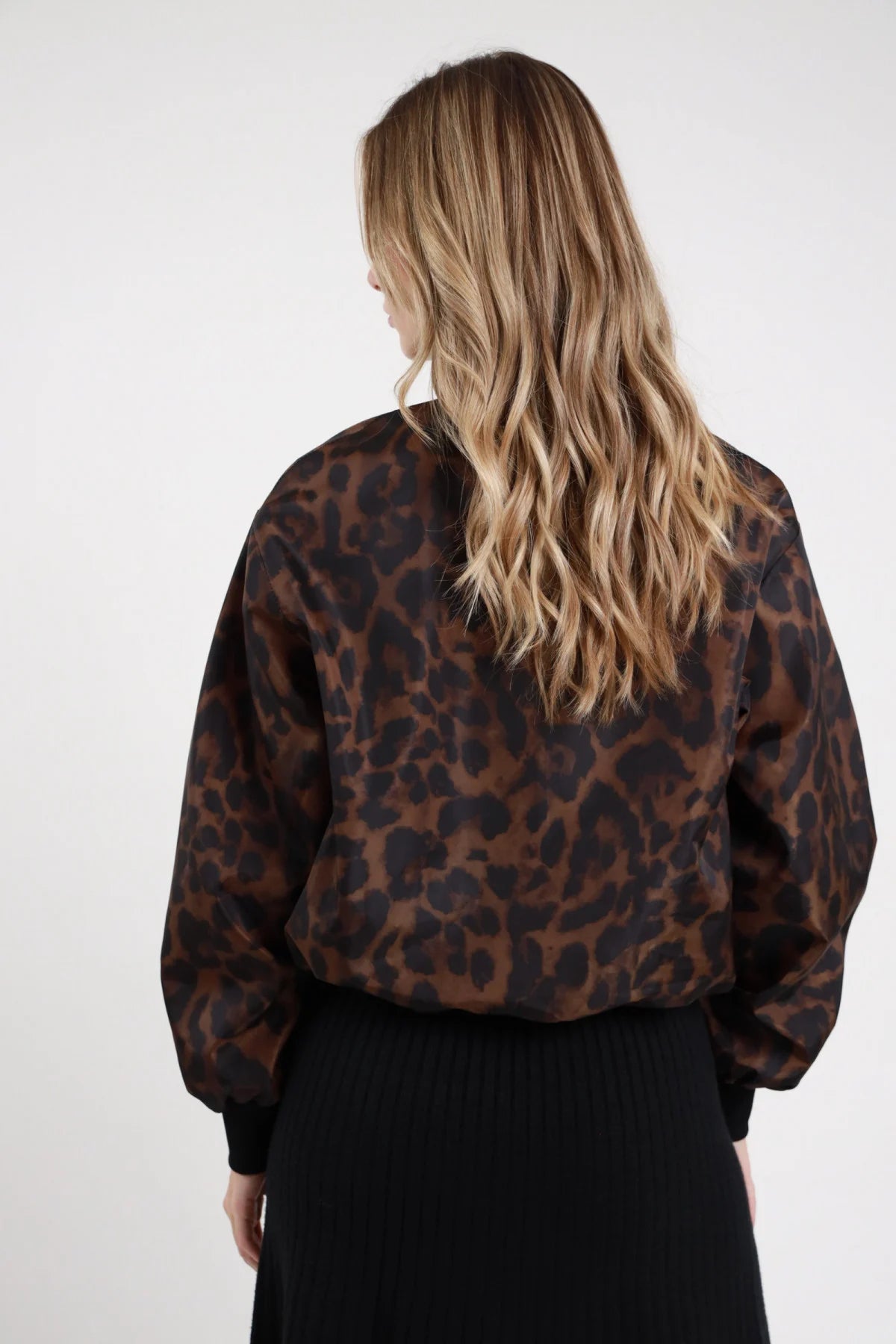 Bomber Nylon Fantasia leopardato marrone cioccolato nero 100% poliestere retro liscio stampa leopardata maxi macchie colletto costina nero bordo fondo costina manica balloon posteriore - modella intera posteriore capelli biondi mossi sfondo bianco gonna midi coste nera