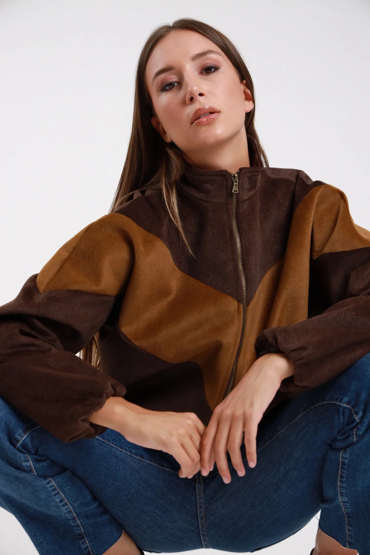 Bomber bicolor flock cioccolato camel chevron frontale busto zip dorata collo alto rialzato - modella busto frontale mani giunte sguardo frontale jeans blu capelli castani lisci