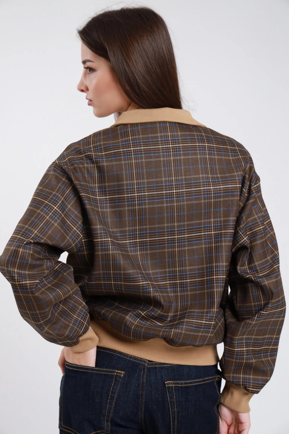Bomber check principe di Galles marrone cammello blu bordi costine contrasto colletto polo abbottonatura bottoni balloon oversize boxy crop retro intera mano tasca posteriore - modella retro intera mano tasca posteriore sguardo laterale capelli castani scuri lisci sfondo bianco jeans blu scuro