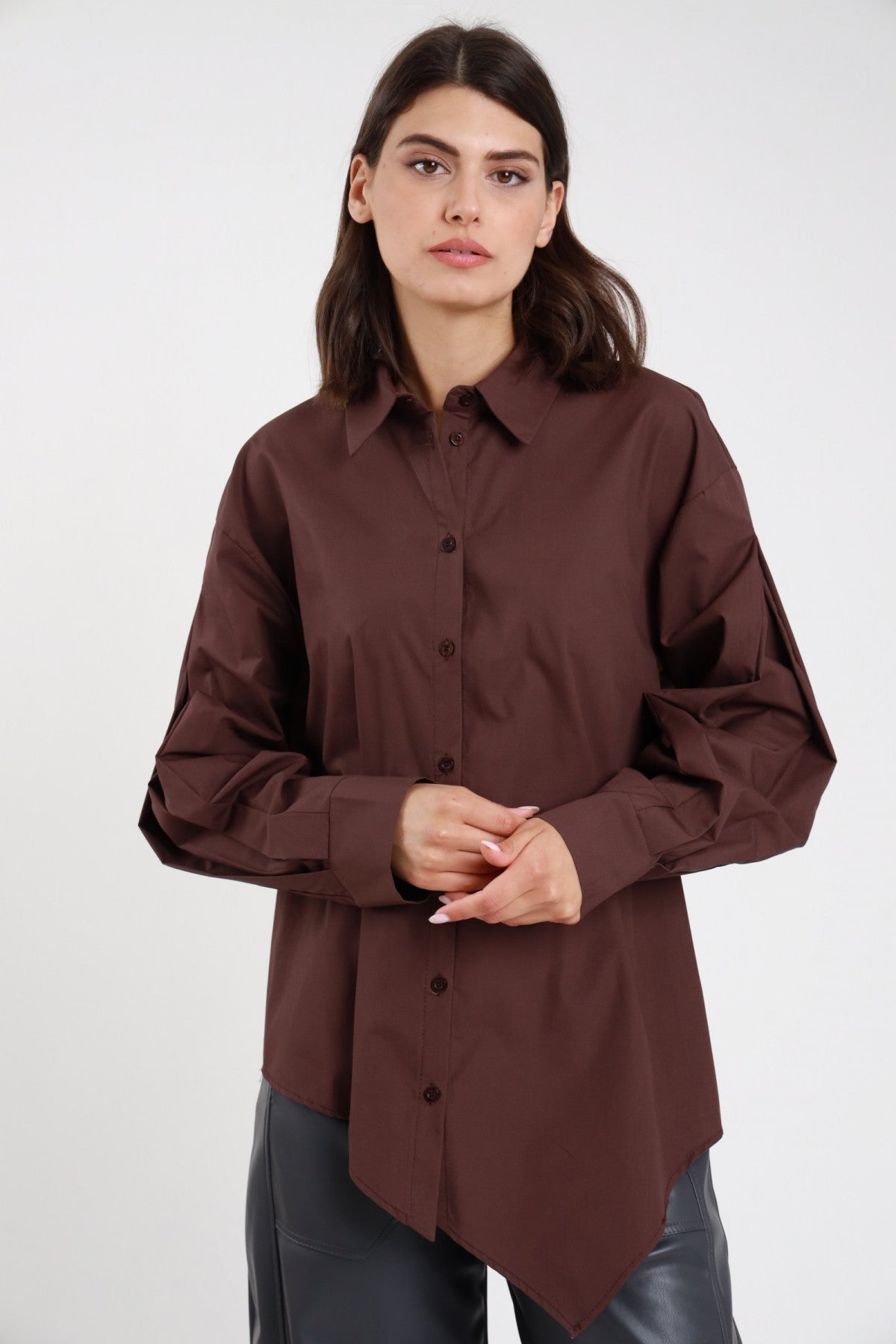 Camicia asimmetrica marrone cioccolato over con orlo a punta e bottoni coordinati abbinata a pantaloni in pelle grigi - vista frontale