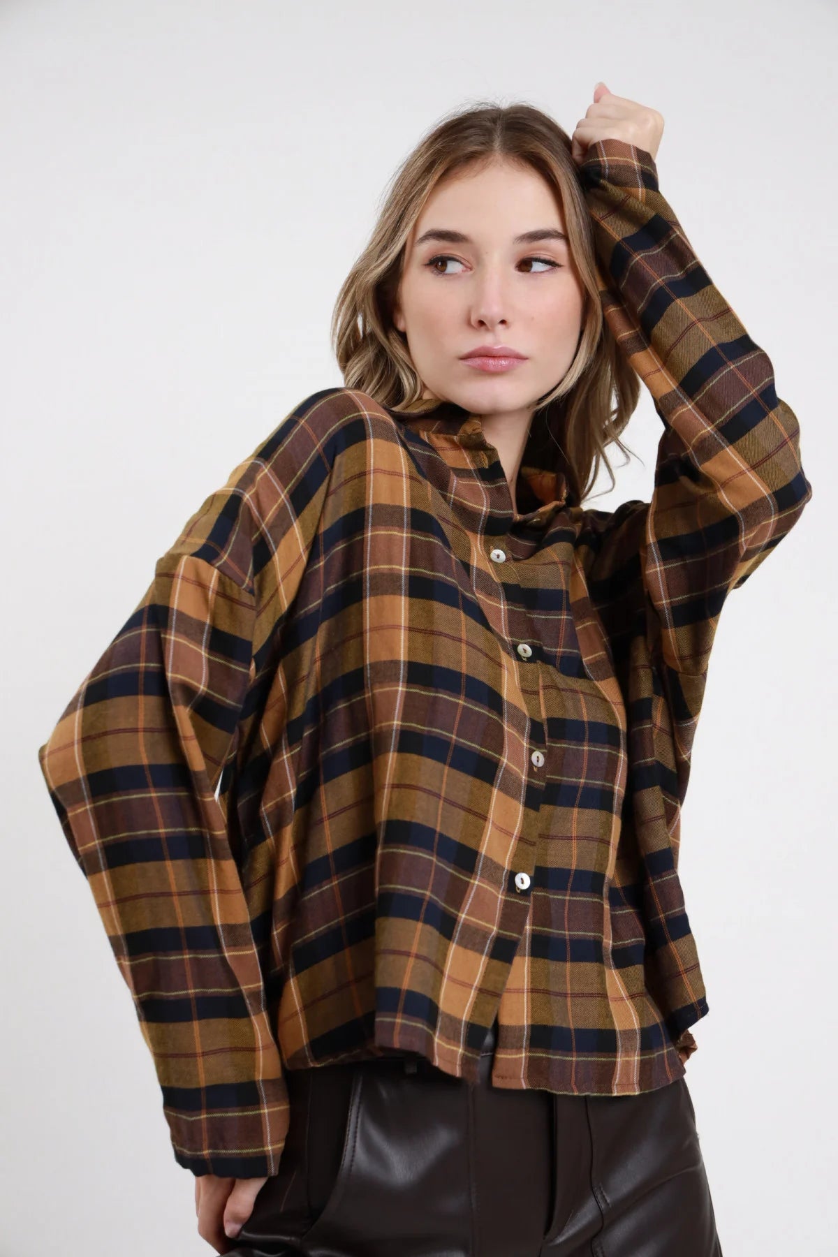 Camicia Oversize Quadri Tartan grigio antracite marrone blu scuro filo rosso verde 57% poliestere 43% viscosa colletto classico aperto bottoni argento manica ampia drop silhouette oversize boxy - modella busto frontale posa mani tasche sguardo frontale capelli castani lisci sfondo bianco gonna a coste marrone