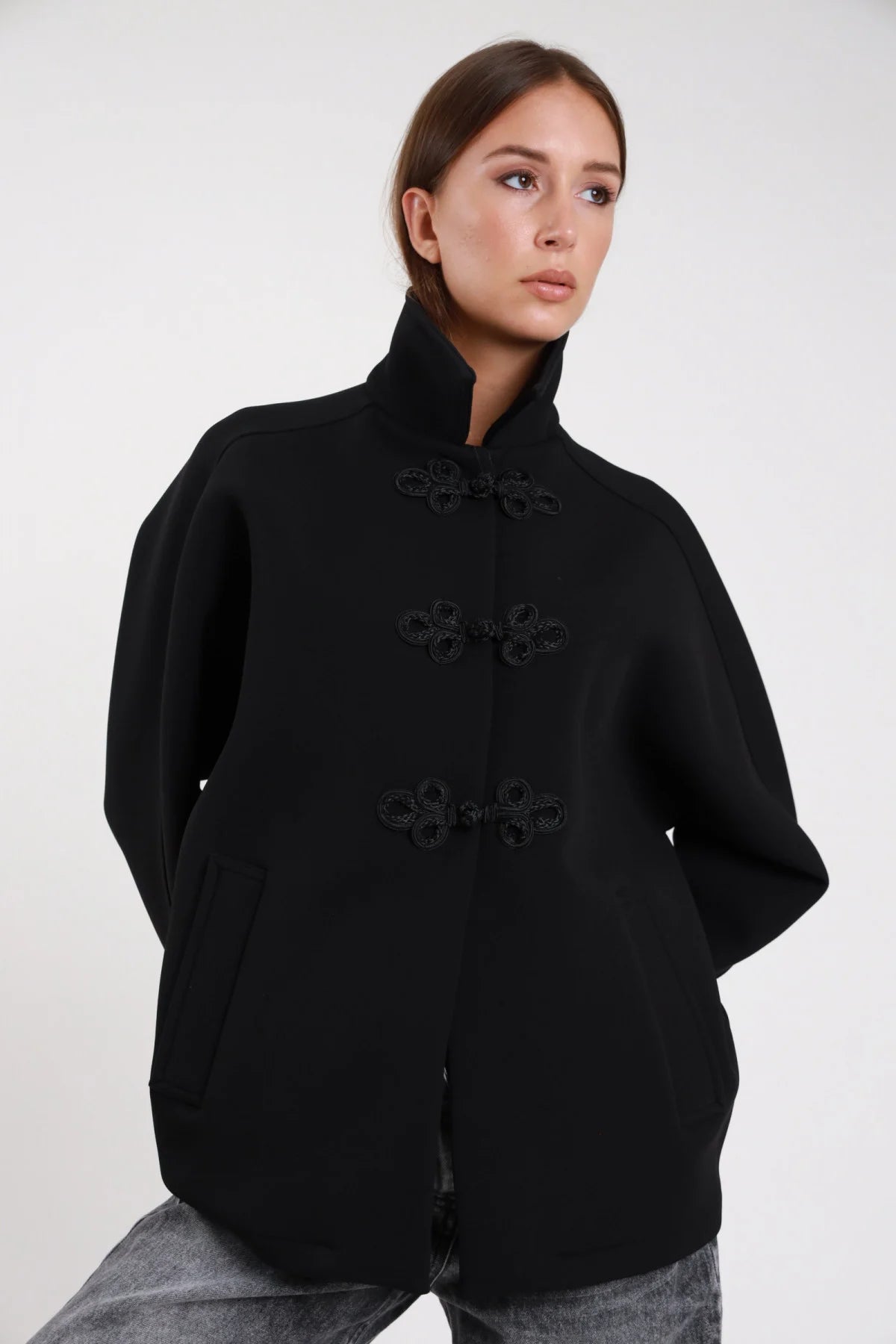 Cappotto alamari verde militare khaki frontale busto mano collo revers colletto classico alamari neri a contrasto frog closure dropped shoulder tasche filo - modella frontale busto mano collo sguardo laterale capelli biondi mossi lunghi