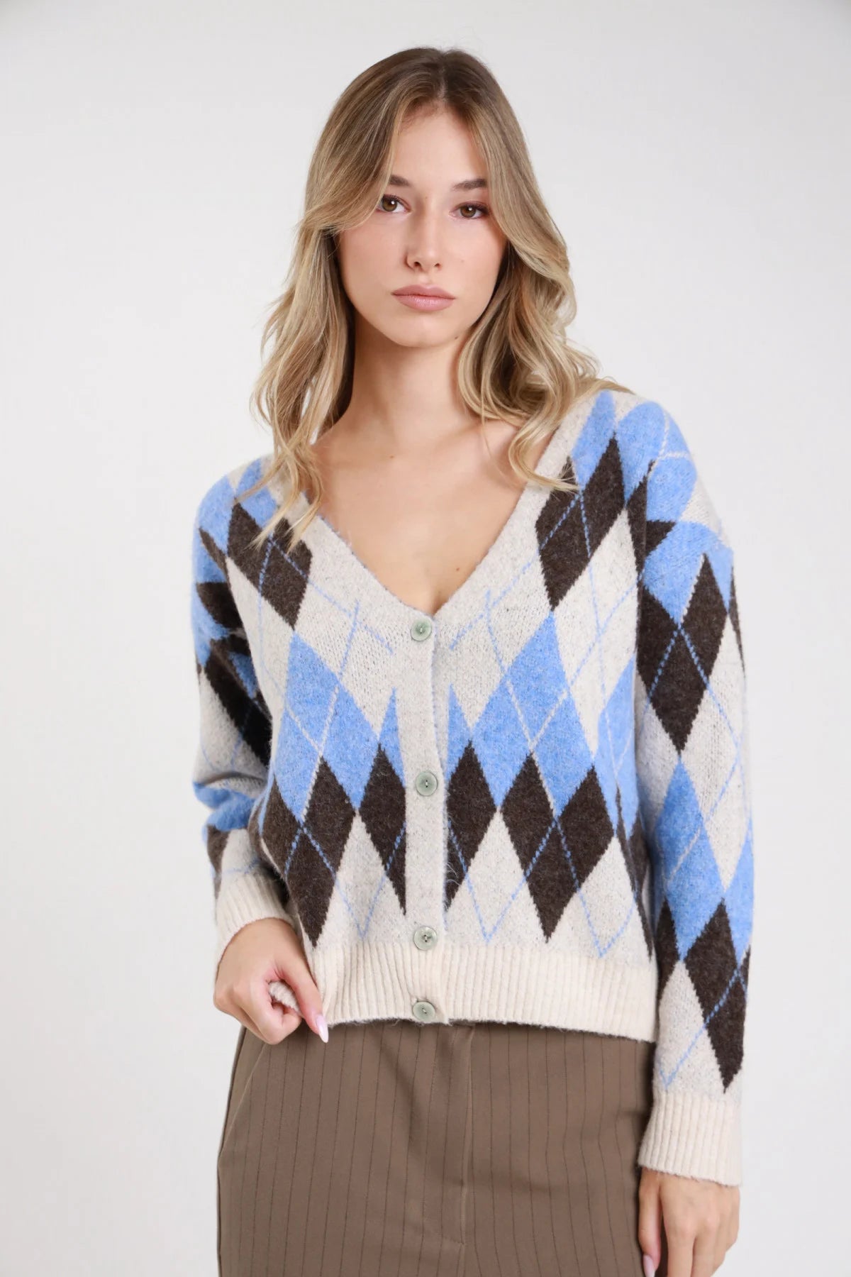 Cardigan rombi argyle panna azzurro cioccolato maglia boxy - modella bionda busto frontale sguardo frontale con gonna a righe grigia