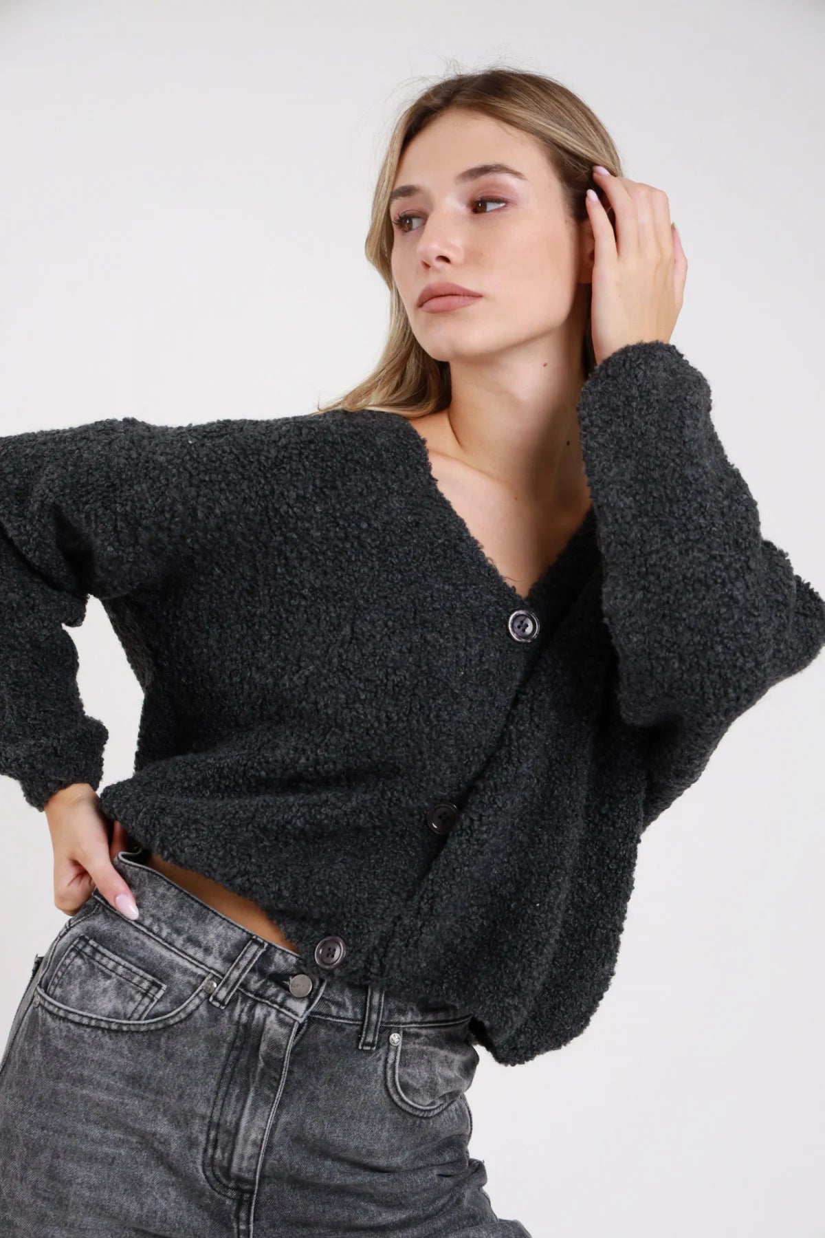 Cardigan bouclé dettaglio texture morbida bottone tono su tono maglia spazzolata effetto alpaca - modella busto ravvicinato tre quarti sguardo laterale capelli biondi ondulati