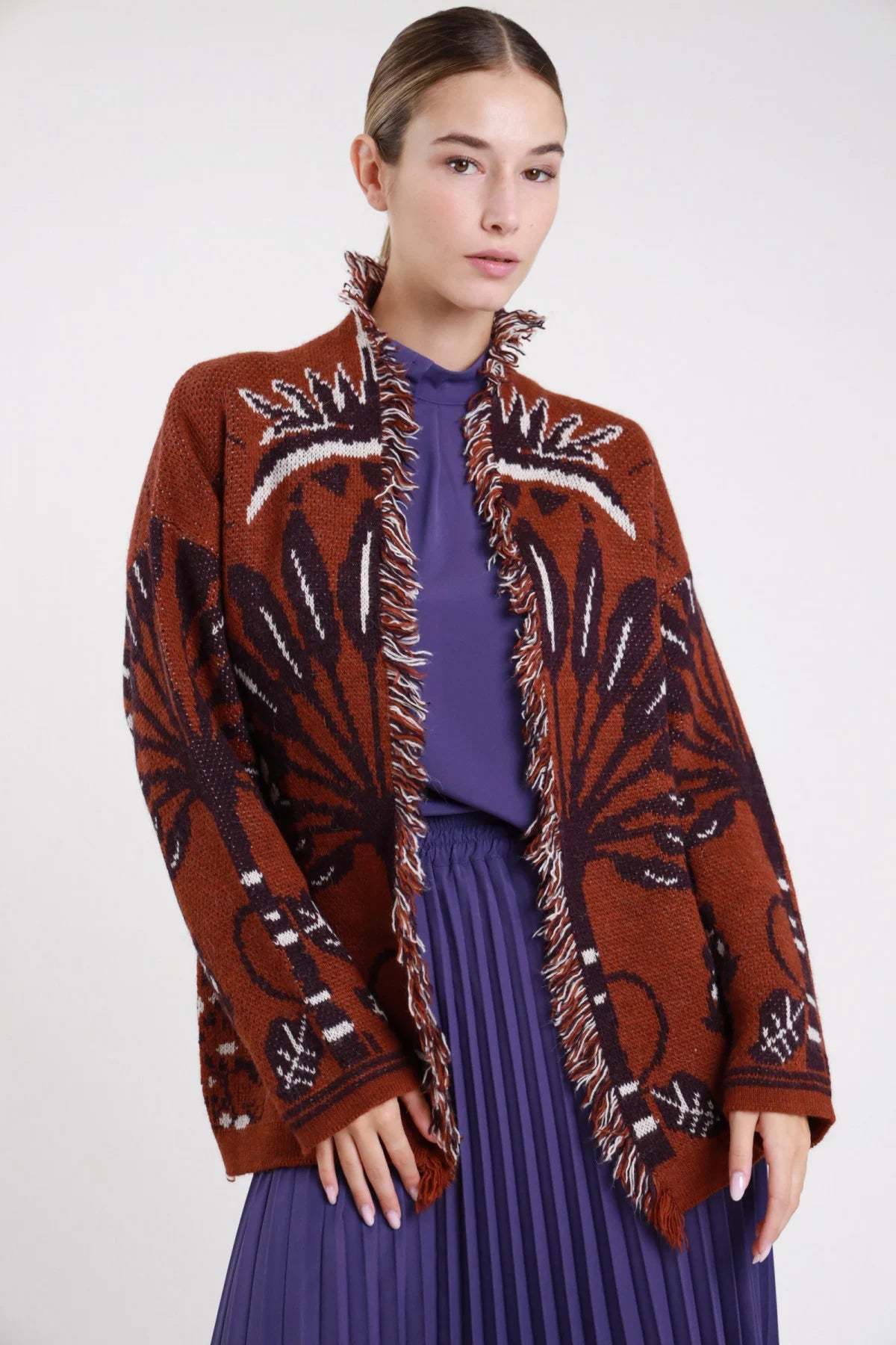 Cardigan jacquard terracotta ruggine nero maxi floreale frange - modella busto tre quarti mani conserte gonna plissé viola camicia viola capelli raccolti