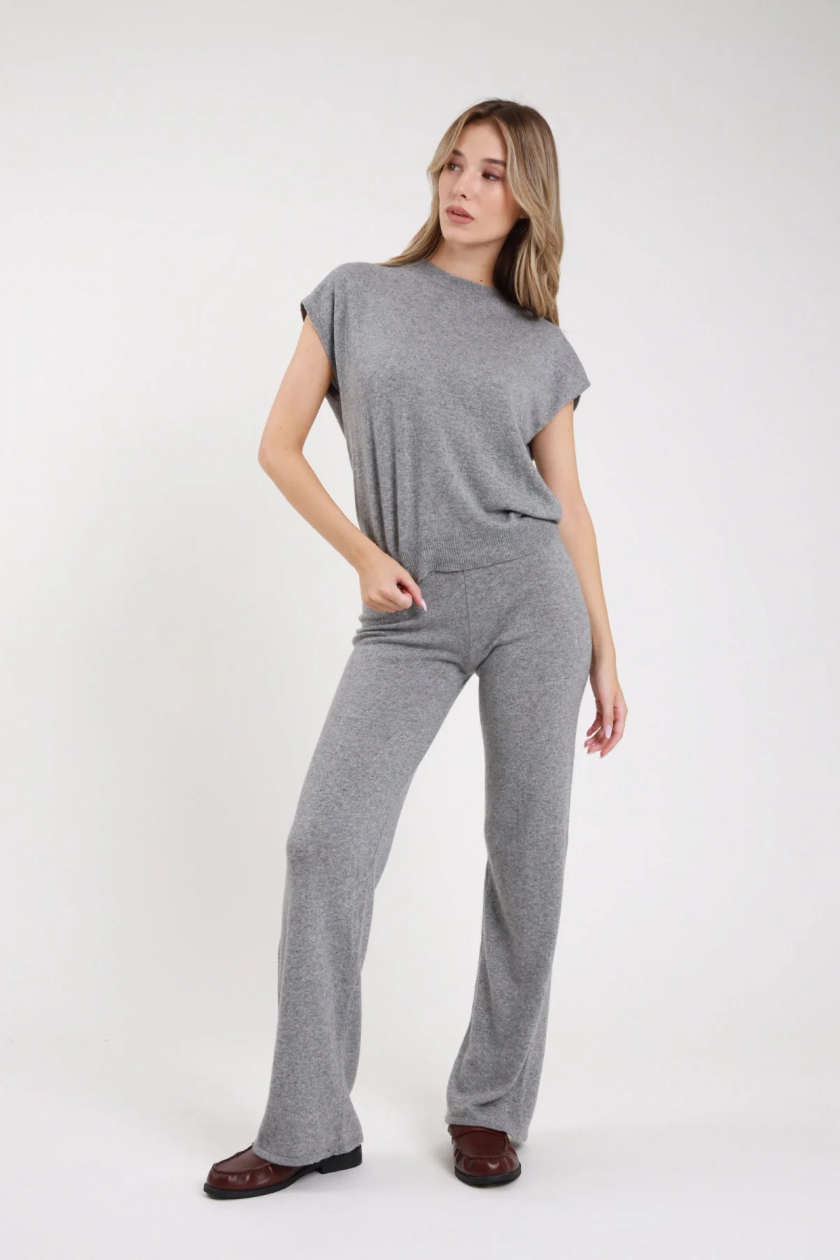 Completo pullover pantalone palazzo grigio melange micro-lurex frontale intera - modella frontale intera mano in tasca sguardo laterale loafer bordeaux capelli biondi lisci