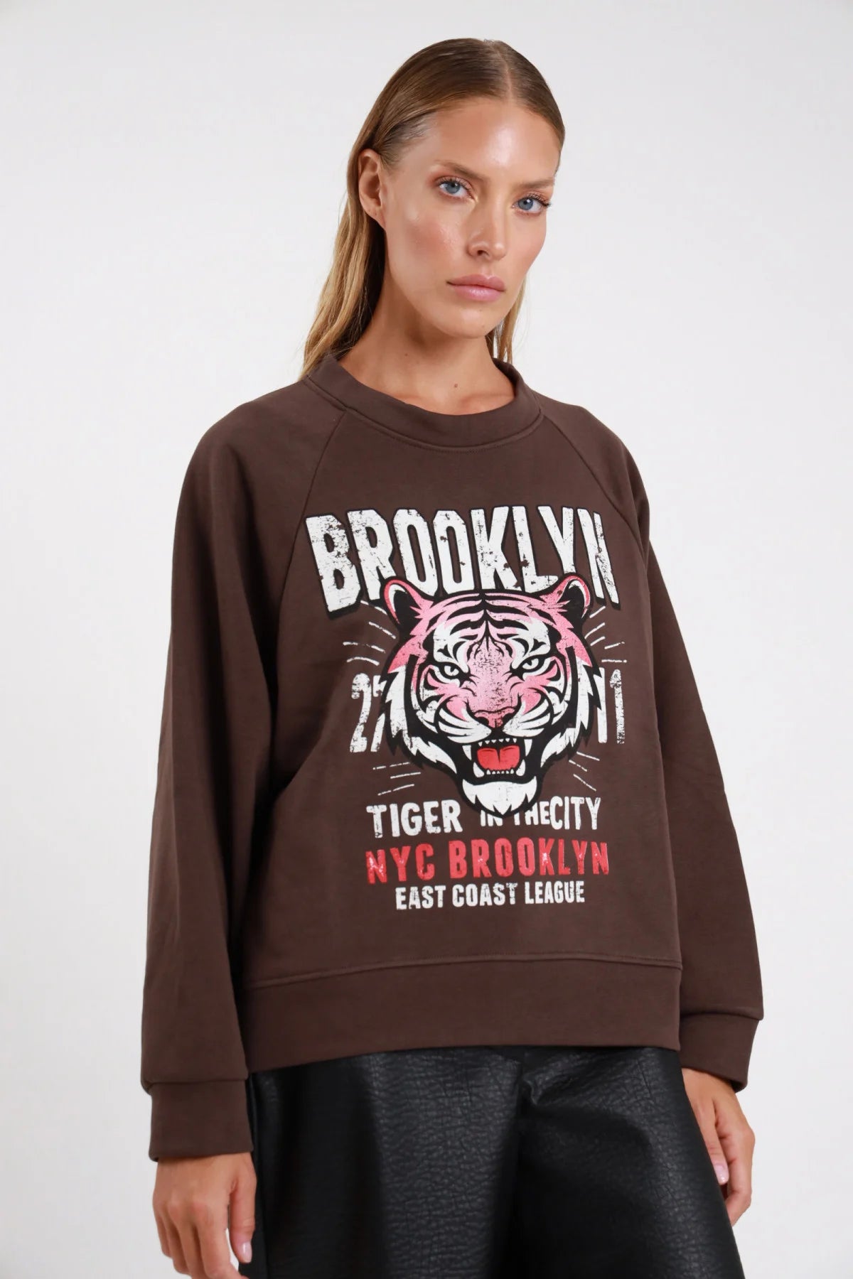 Felpa Brooklyn tiger cioccolato espresso maxi stampa frontale busto oversize raglan - modella busto tre quarti sguardo frontale stampa tigre rosa gonna ecopelle nera capelli biondi raccolti