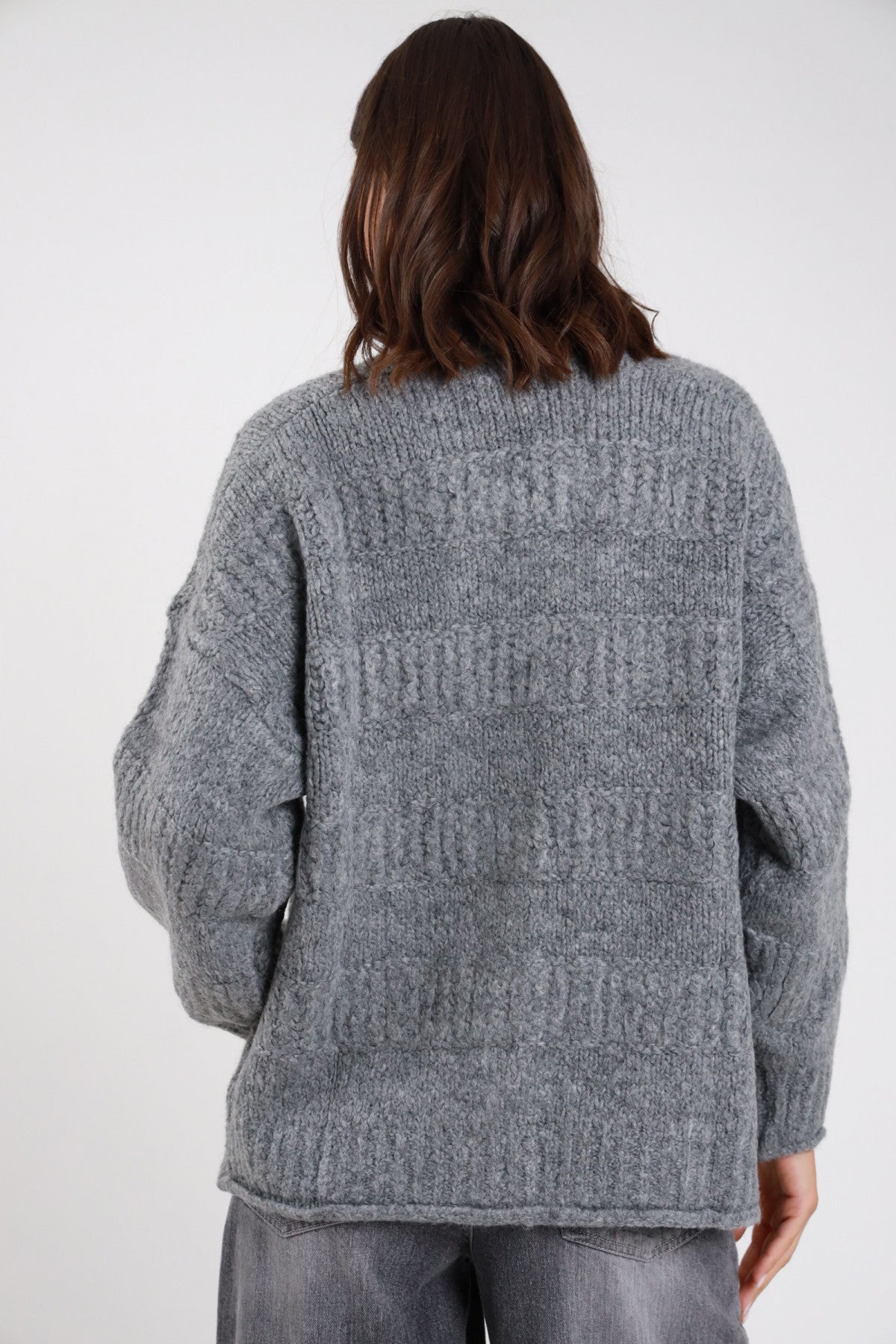 Cardigan over maglia eyelash fluffy trecce cable grigio melanges multicolor frontale busto sguardo frontale scollo V bordo sfrangiato 3 bottoni tortoise lavorazione trecce cable tasche toppa corpo oversize manica balloon - modella frontale busto sguardo frontale intenso jeans grigi capelli castani mossi