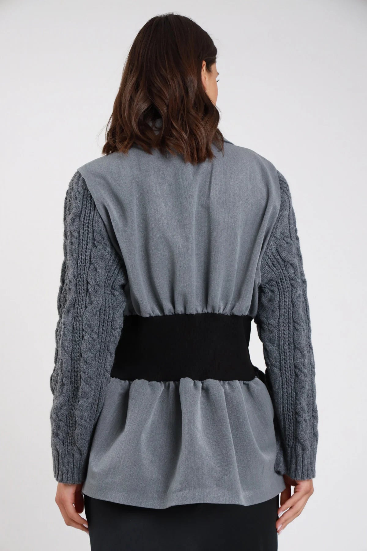 Blazer sartoriale grigio ardesia maniche maglia trecce volumetriche revers sciallato cucitura contrasto spilla gioiello perla stella strass monopetto bottone fascia elastica nera vita peplum frontale tre quarti mano colletto aperto - modella frontale tre quarti mano colletto sguardo laterale capelli castani medi sfondo bianco gonna nera