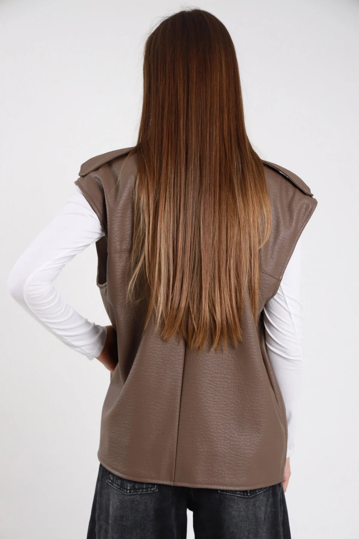Chiodo smanicato ecopelle tortora taupe donna - vista posteriore con texture crinkle e jeans neri
