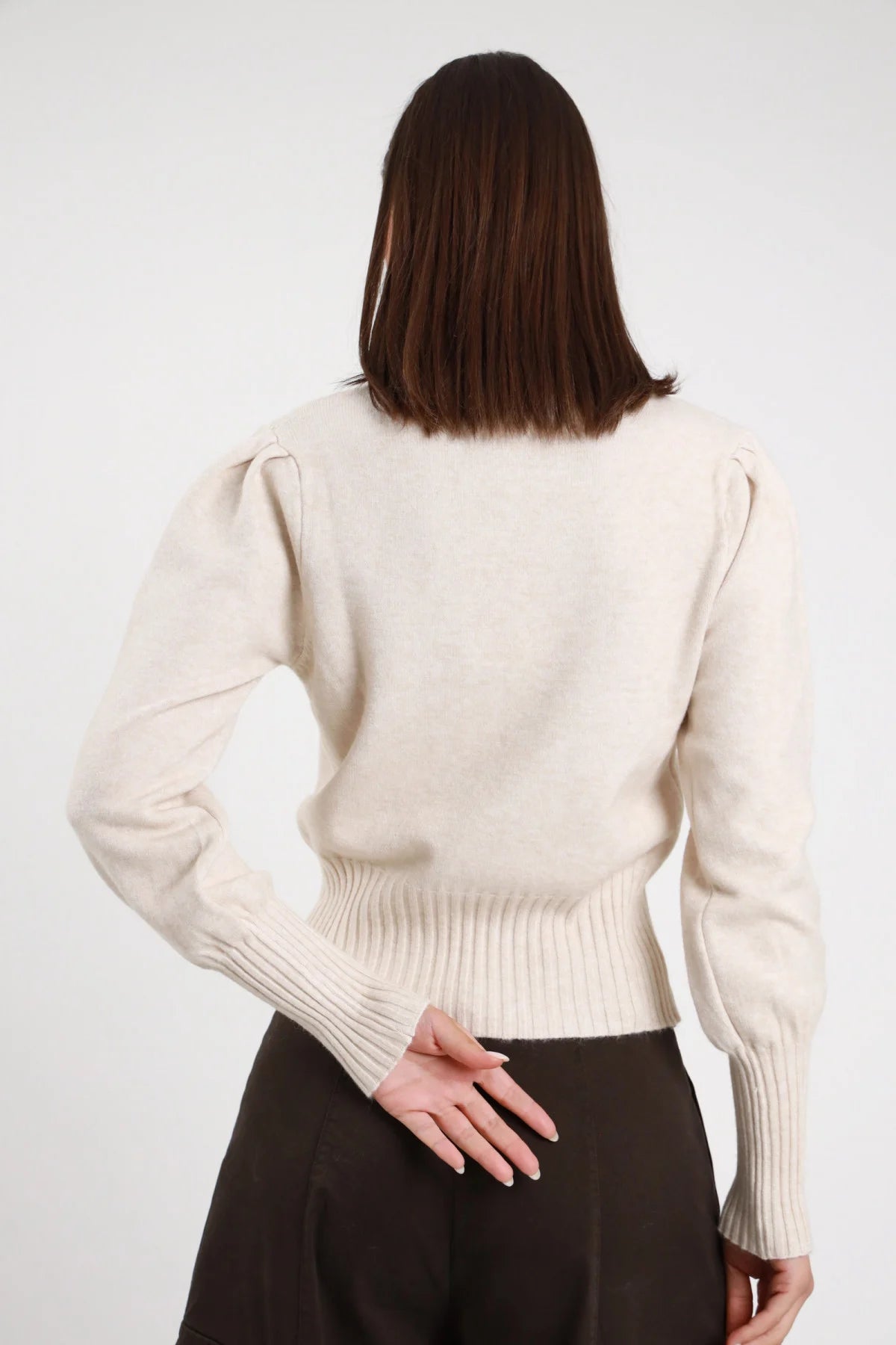 Pullover Maniche Palloncino panna avorio 45% viscosa girocollo manica puff palloncino voluminosa alzata arco polsino costina largo bordo costina boxy crop frontale braccio alzato posa dinamica - modella frontale braccio alzato arco posa dinamica sguardo intenso capelli castani lisci sfondo bianco gonna cioccolato abbinata