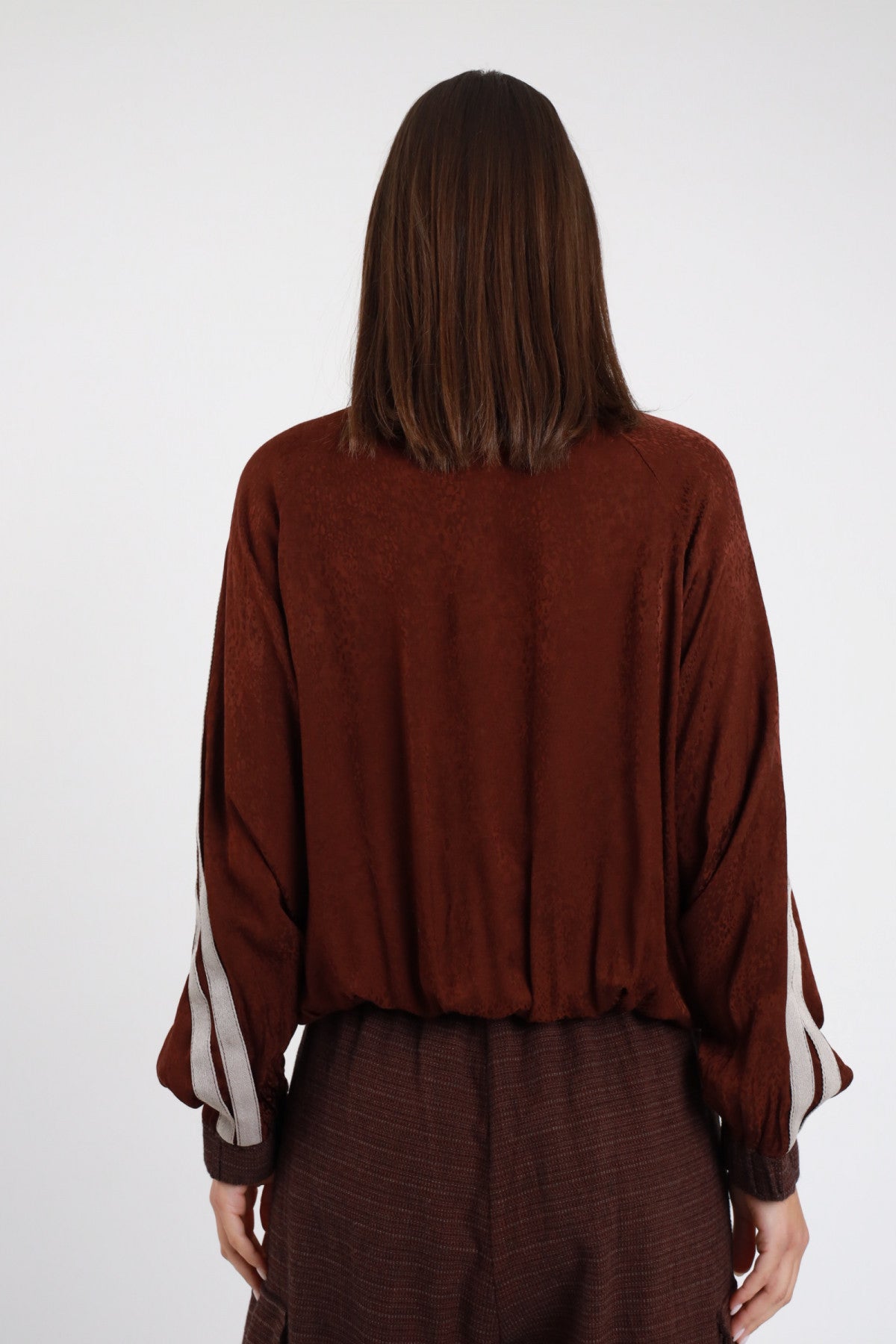 Bomber Bande cioccolato bordeaux scuro 55% rayon 45% viscosa bande doppie beige panna dalla spalla al polso colletto alto costina zip frontale argento corpo maglia strutturata micro-texture maniche oversize batwing bordo fondo elasticizzato frontale busto - modella busto frontale mano colletto sguardo alto capelli castani lisci sfondo bianco gonna plissé bordeaux scuro coordinata