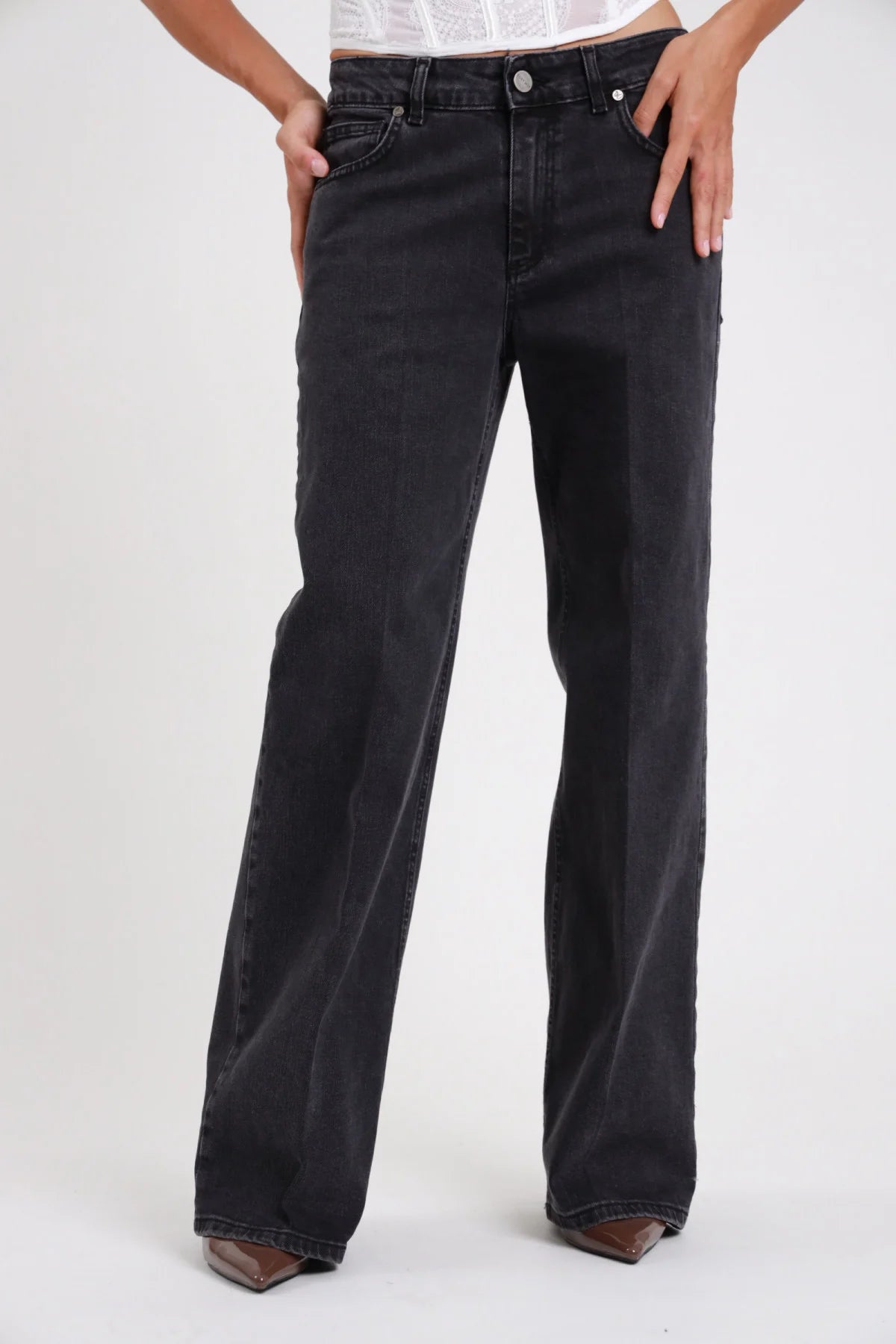 Jeans palazzo wide-leg nero washed dettaglio gamba vita media zip bottone tasche anteriori - modella busto vita dettaglio gamba wide-leg top bustino bianco stivaletti marrone