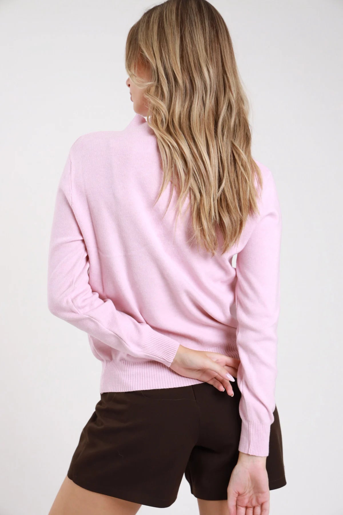 Lupetto bottoni rosa cipria baby pink retro intera manica lunga polsino costina arricciato orlo dritto corpo regular - modella retro intera mano fianco sguardo basso shorts cioccolato capelli biondi mossi lunghi