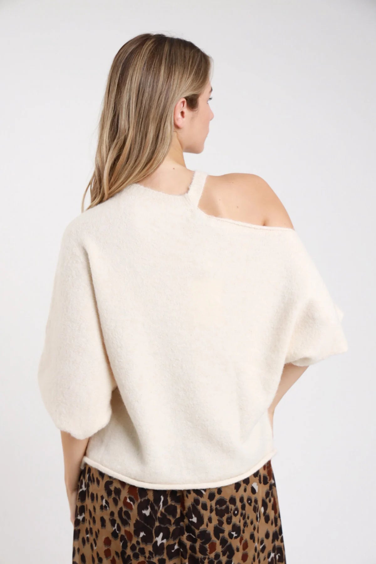 Pullover cut-out azzurro baby blue cut-out spalla mock neck maniche batwing frontale - modella tre quarti frontale mano bassa sguardo frontale jeans grigio glitter capelli biondi