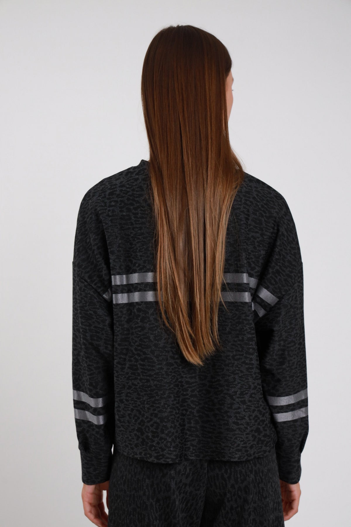 Maglia Animalier Bande Satinate antracite grigio scuro melange stampa maculata 2 bande satinate grigio retro spalle manica batwing bande polso posteriore - modella busto posteriore posa statica capelli castani sfondo bianco pantaloni animalier antracite coordinati
