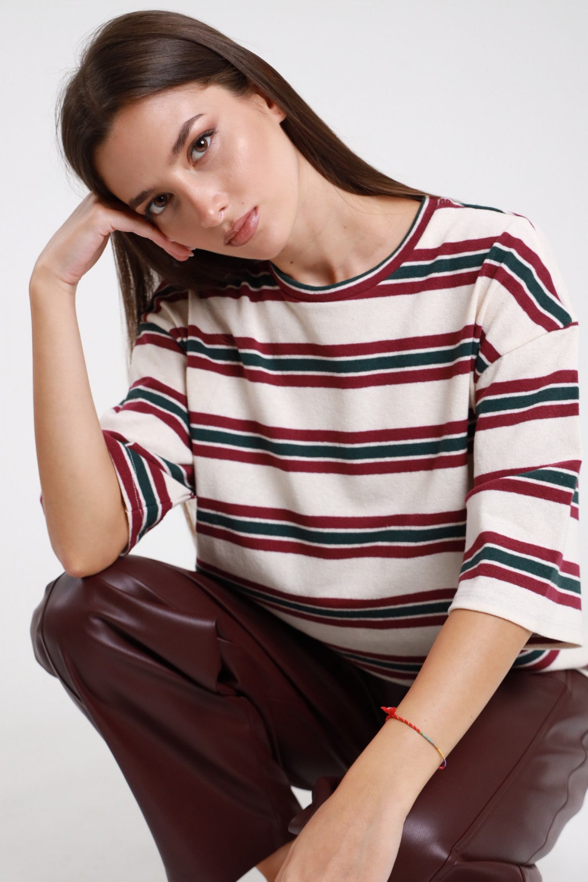 T-shirt righe boxy panna bordeaux verde donna maniche 3/4 - vista seduta con pantaloni in ecopelle bordeaux