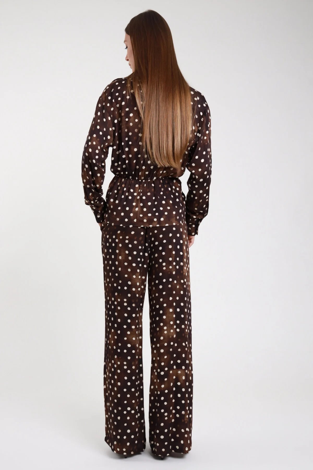 Pantalone palazzo pois marrone cioccolato - modella vista posteriore intera con top wrap pois coordinato e capelli lisci lunghi