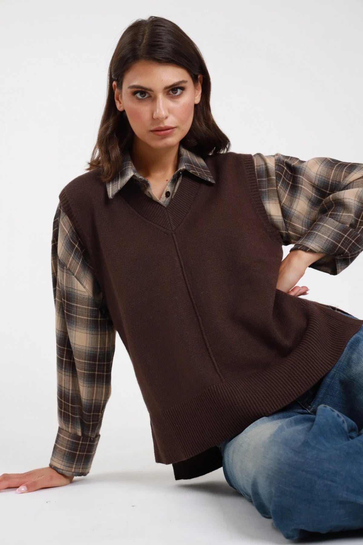 Gilet scollo V marrone abbinato a camicia check - modella seduta