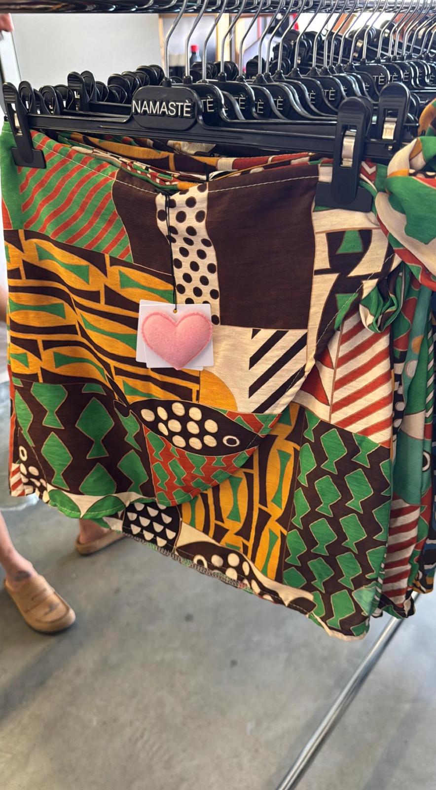 Pareo mini Namaste con stampa etnica africana patchwork, motivi geometrici multicolore verde marrone giallo e rosso con cuore rosa applicato