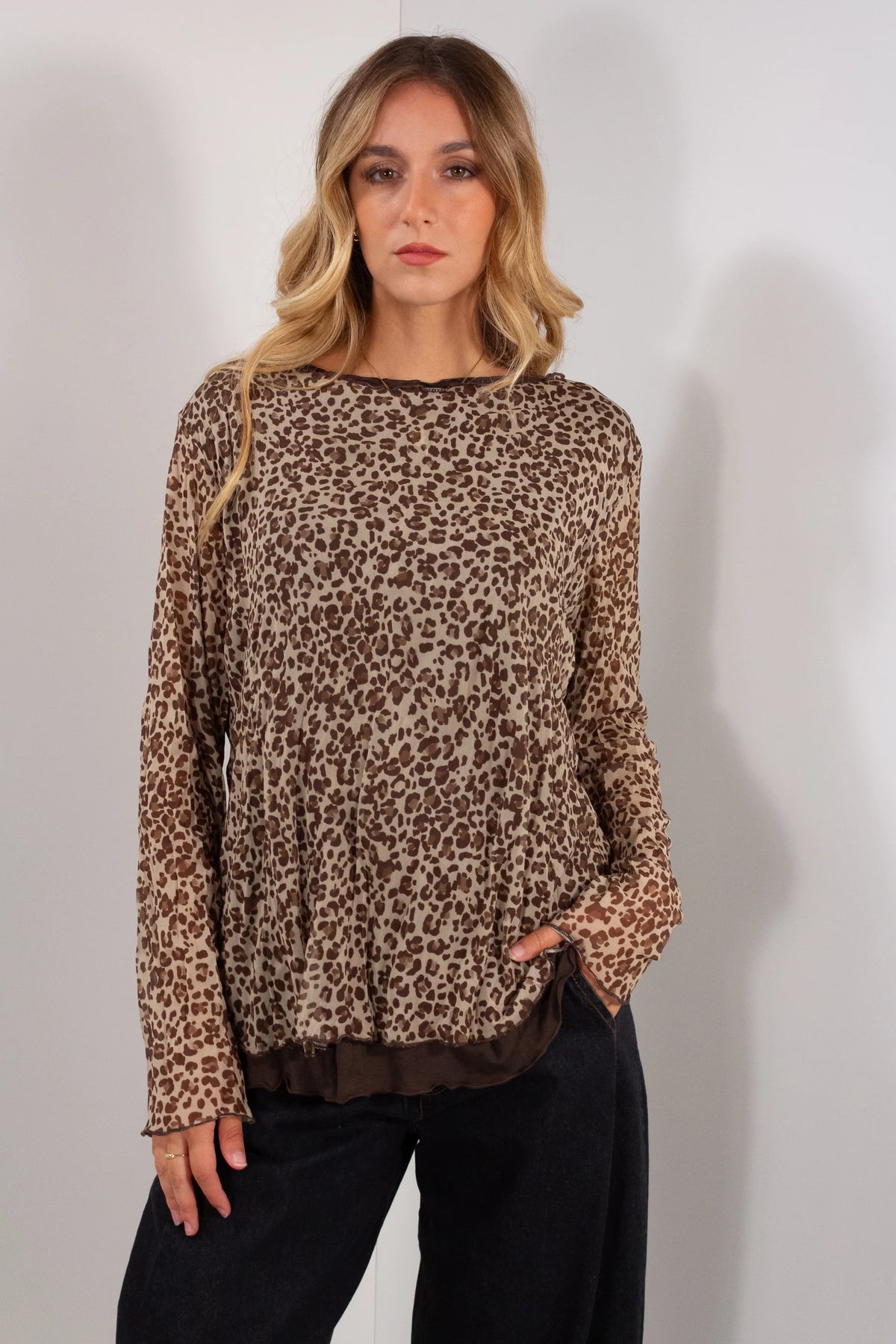 Maglia tulle maculato leopardato camel vista frontale con bordi marrone scuro e jeans neri wide leg