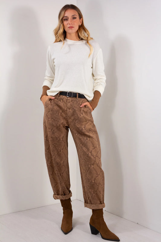 Pantalone ovetto fantasia pitonata marrone camel vista frontale intera con maglia girocollo panna e stivaletti marroni