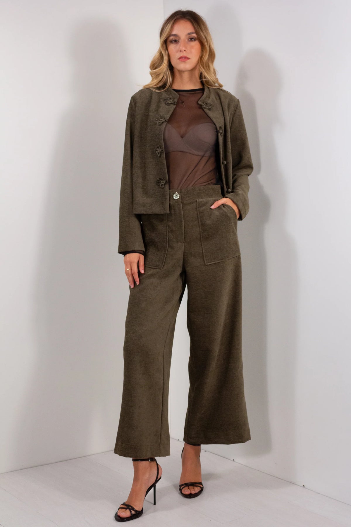 Pantalone ampio velluto verde militare wide leg vista frontale con blazer coordinato e body trasparente marrone