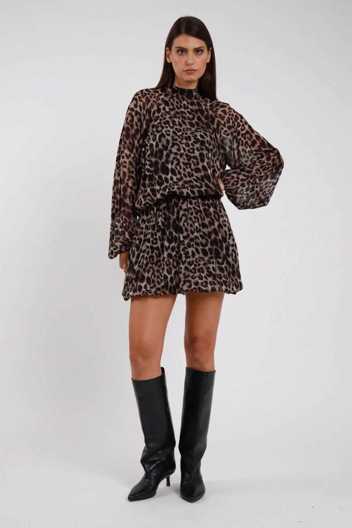 Abito Animalier leopardato maculato beige marrone nero viscosa colletto alto rouches manica batwing cintura elastica gonna mini balloon frontale intera posa statica - modella frontale intera sguardo frontale capelli castani lisci sfondo bianco stivali neri alti ginocchio