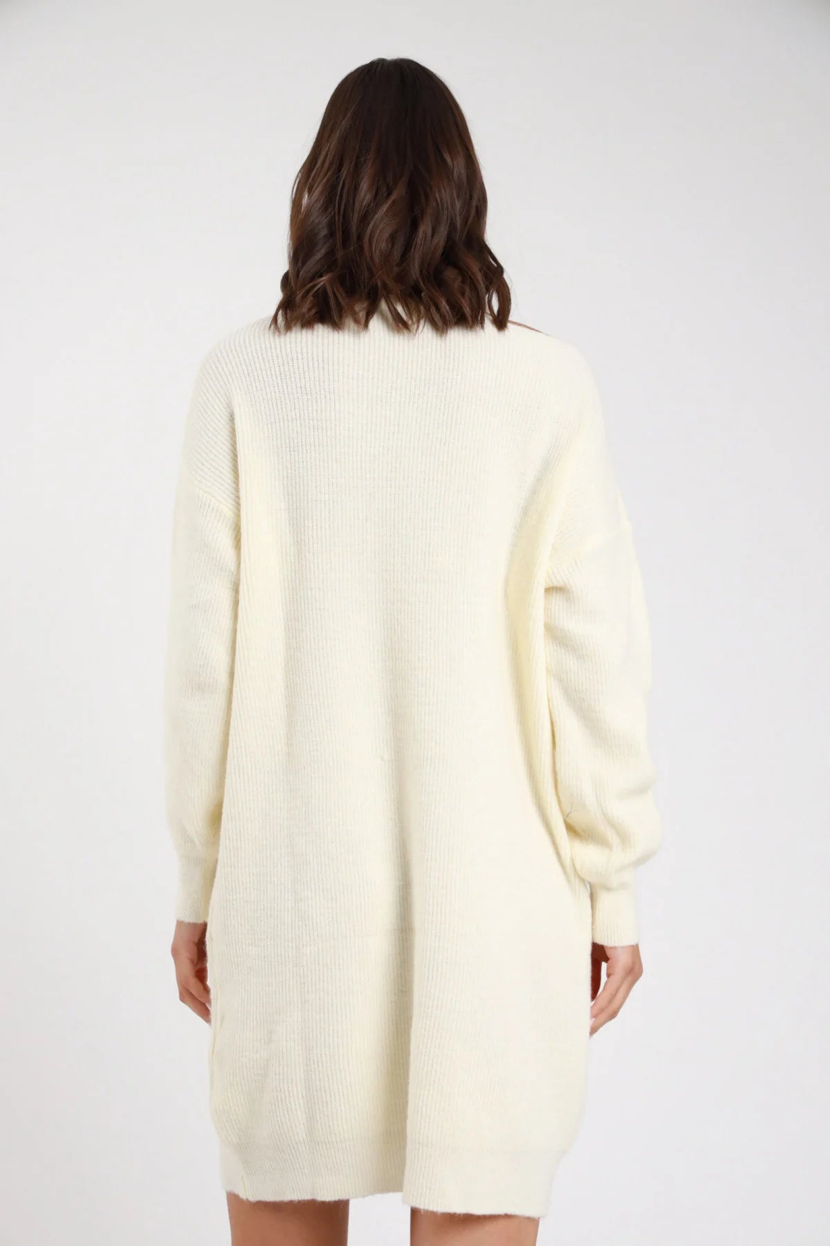 Abito maglia cut-out panna avorio retro intera collo alto mock neck rollato manica batwing dropped shoulder polsino coste corpo oversize relaxed orlo coste mini lavorazione coste rib-knit - modella retro intera sguardo basso capelli castani mossi sfondo bianco