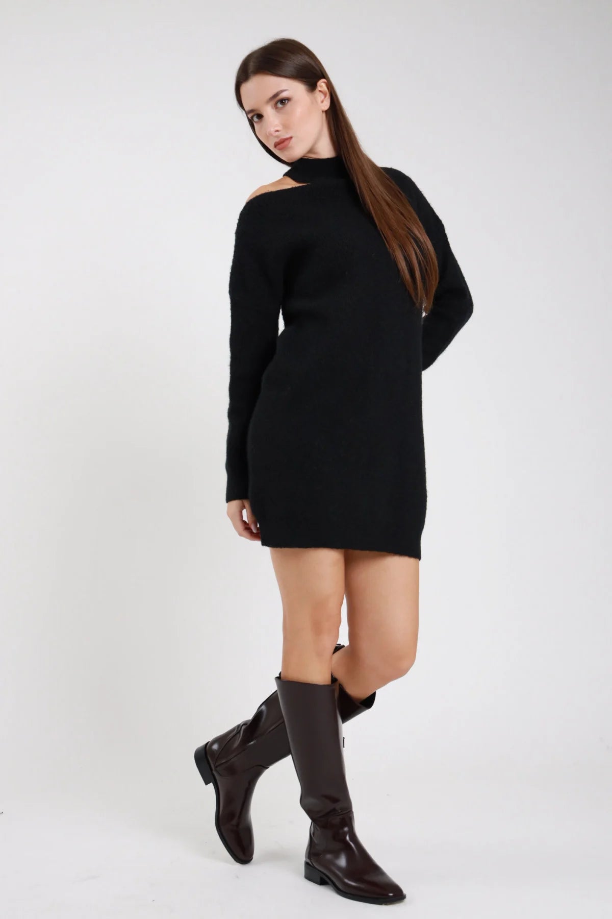 Abito maglia cut-out nero frontale intera laterale cut-out asimmetrico spalla off-shoulder collo alto mock neck manica batwing drappeggiante polsino coste corpo oversize mini orlo coste stivali neri tacco - modella frontale intera laterale sguardo laterale intenso stivali neri tacco capelli castani lisci sfondo bianco