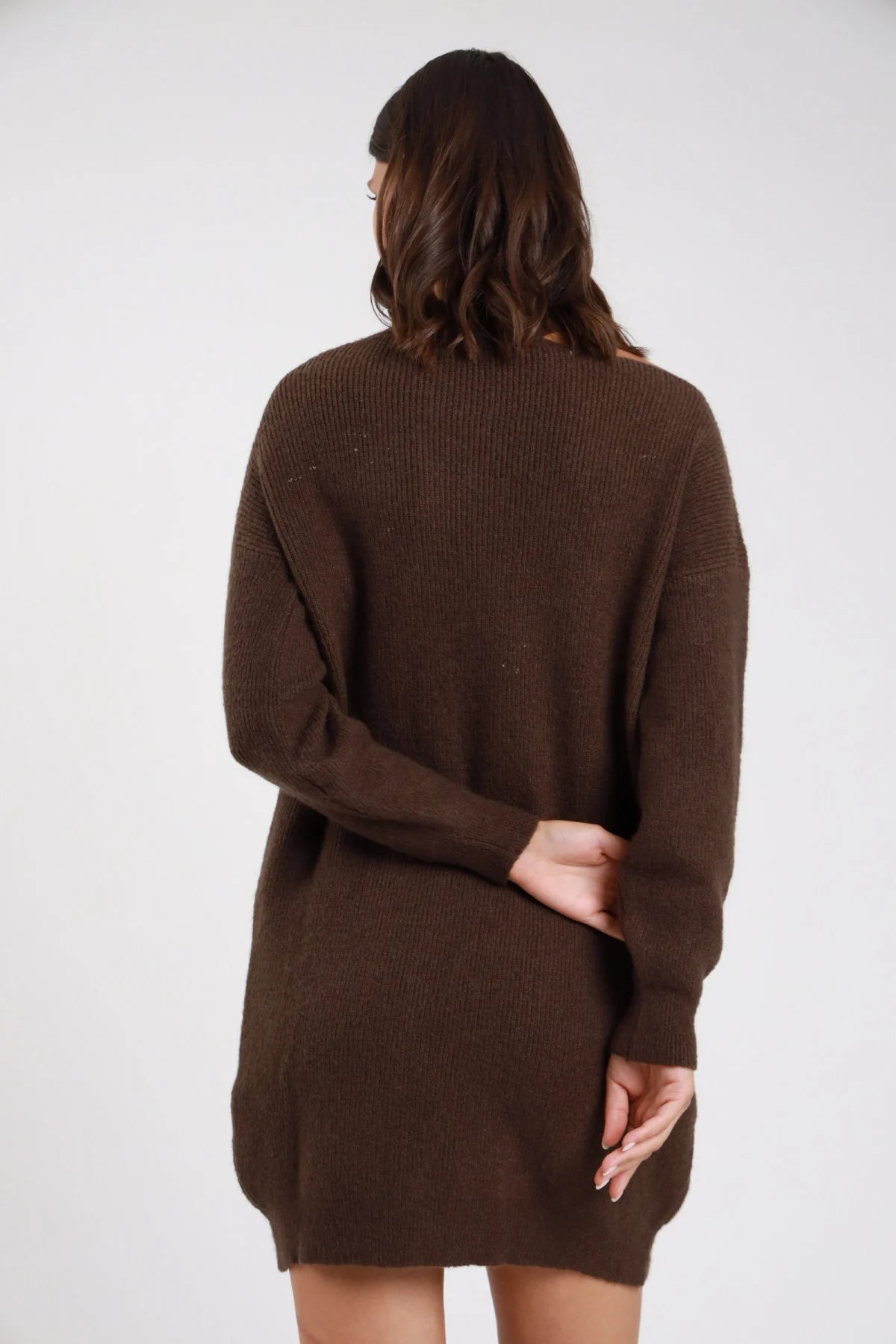 Abito maglia cut-out cioccolato moro cacao frontale intera sguardo laterale collo alto mock neck cut-out asimmetrico off-shoulder manica batwing drappeggiante polsino coste corpo oversize mini orlo coste stivali neri - modella frontale intera sguardo laterale intenso stivali neri capelli castani lisci sfondo bianco