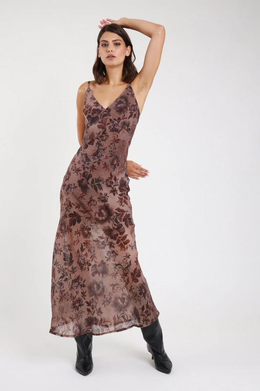 Abito lungo fantasia floreale botanica marrone bordeaux malva donna slip dress maxi scollo V profondo spalline sottili schiena scoperta effetto trumpet - vista frontale intera braccio alzato con stivaletti neri