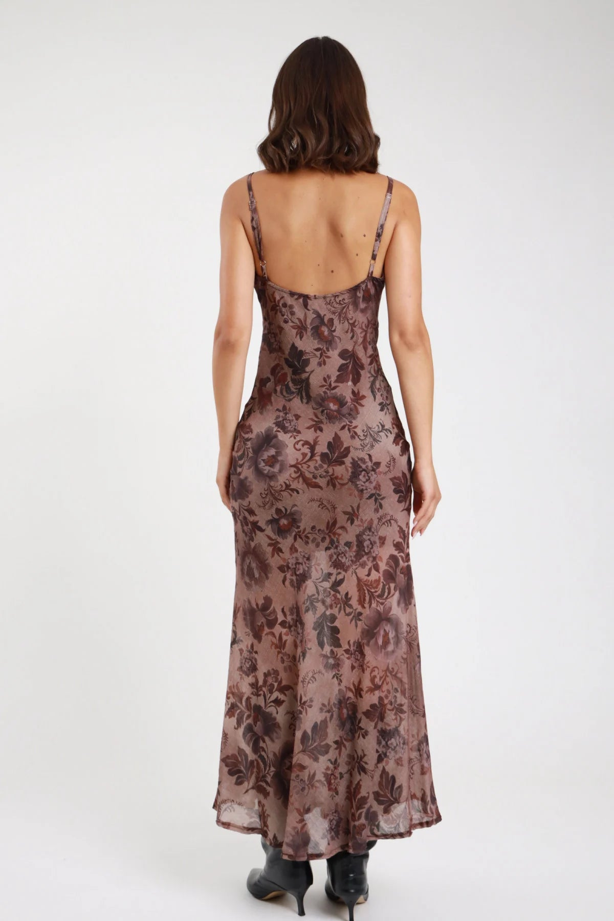 Abito lungo fantasia floreale botanica marrone bordeaux malva donna slip dress maxi schiena scoperta bassa spalline sottili effetto trumpet mermaid - vista posteriore intera con stivaletti neri