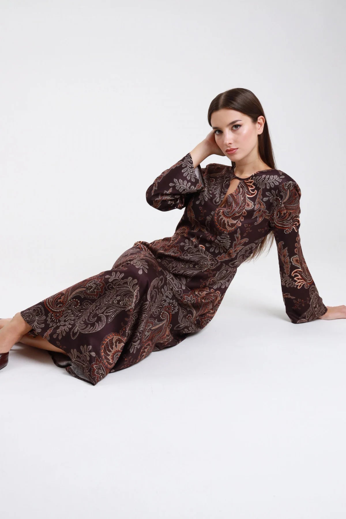 Abito midi viscosa fantasia paisley bordeaux rame - modella seduta sul pavimento vista tre quarti