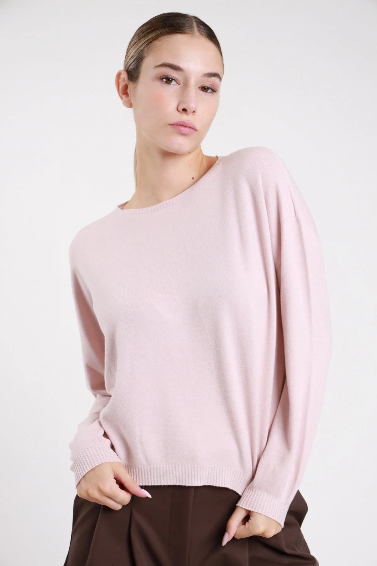 Pullover barchetta blu navy maglia fine crop - modella busto tre quarti mano sulla testa sguardo obliquo con pantaloni cioccolato capelli raccolti coda