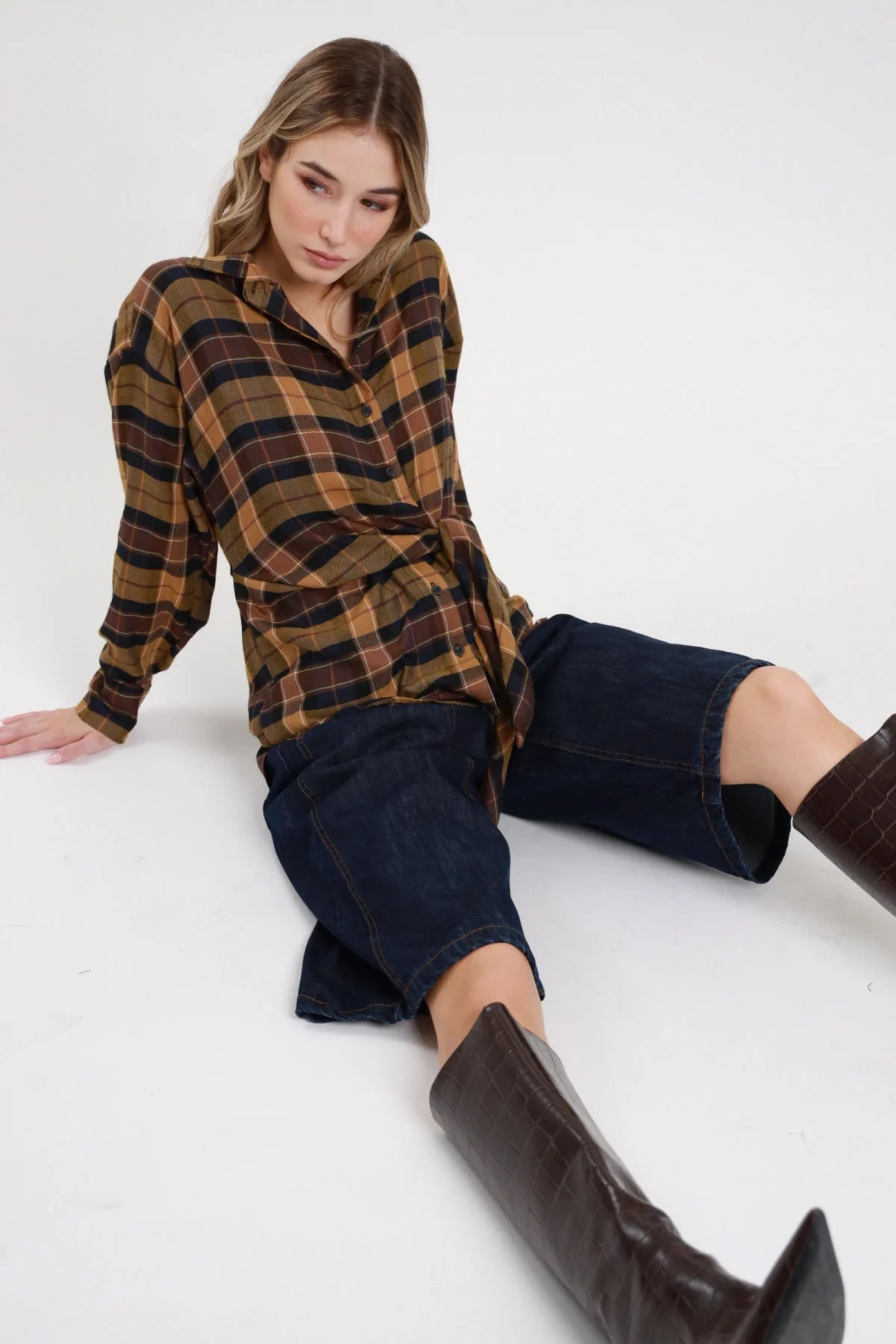 Bermuda denim Susy Mix blu scuro indossato da modella seduta con camicia a quadri e stivali
