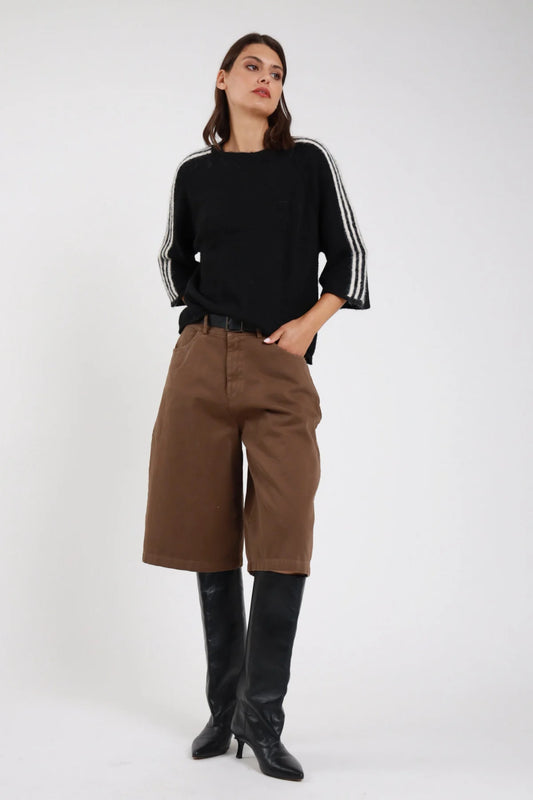 Bermuda culottes wide leg tabacco cammello marrone medio frontale intera vita alta piega sartoriale cintura pelle nera fibbia argento tasche laterali gamba wide leg below-knee orlo dritto stivali neri al ginocchio - modella frontale intera sguardo laterale con felpa nera righe bianche stivali neri al ginocchio capelli castani lisci sfondo bianco