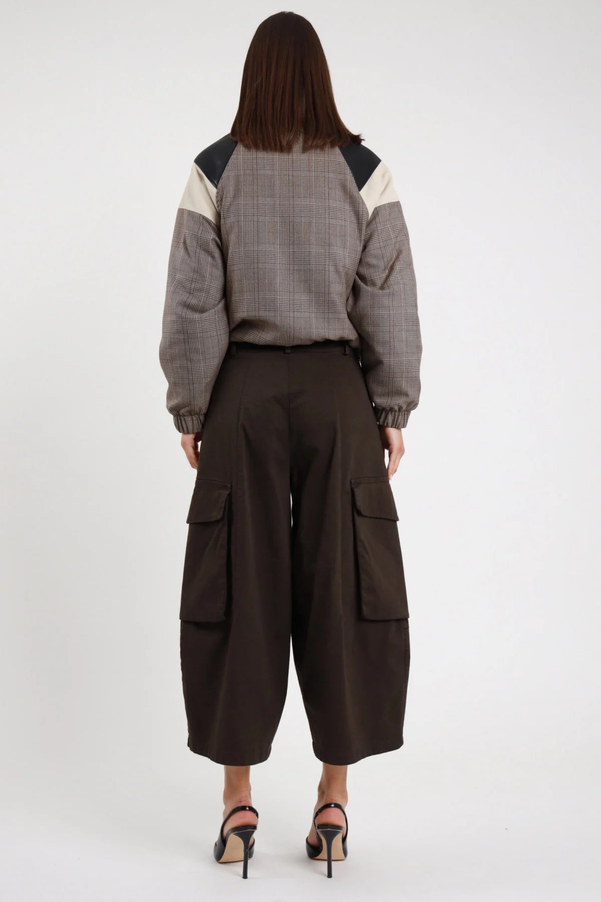 Bermuda Tasconi cioccolato marrone scuro 97% cotone tasconi cargo applicati visibili da dietro gamba wide leg culotte posteriore intera - modella intera posteriore capelli castani scuri lisci sfondo bianco bomber check color block grigio panna nero abbinato slingback tacco neri