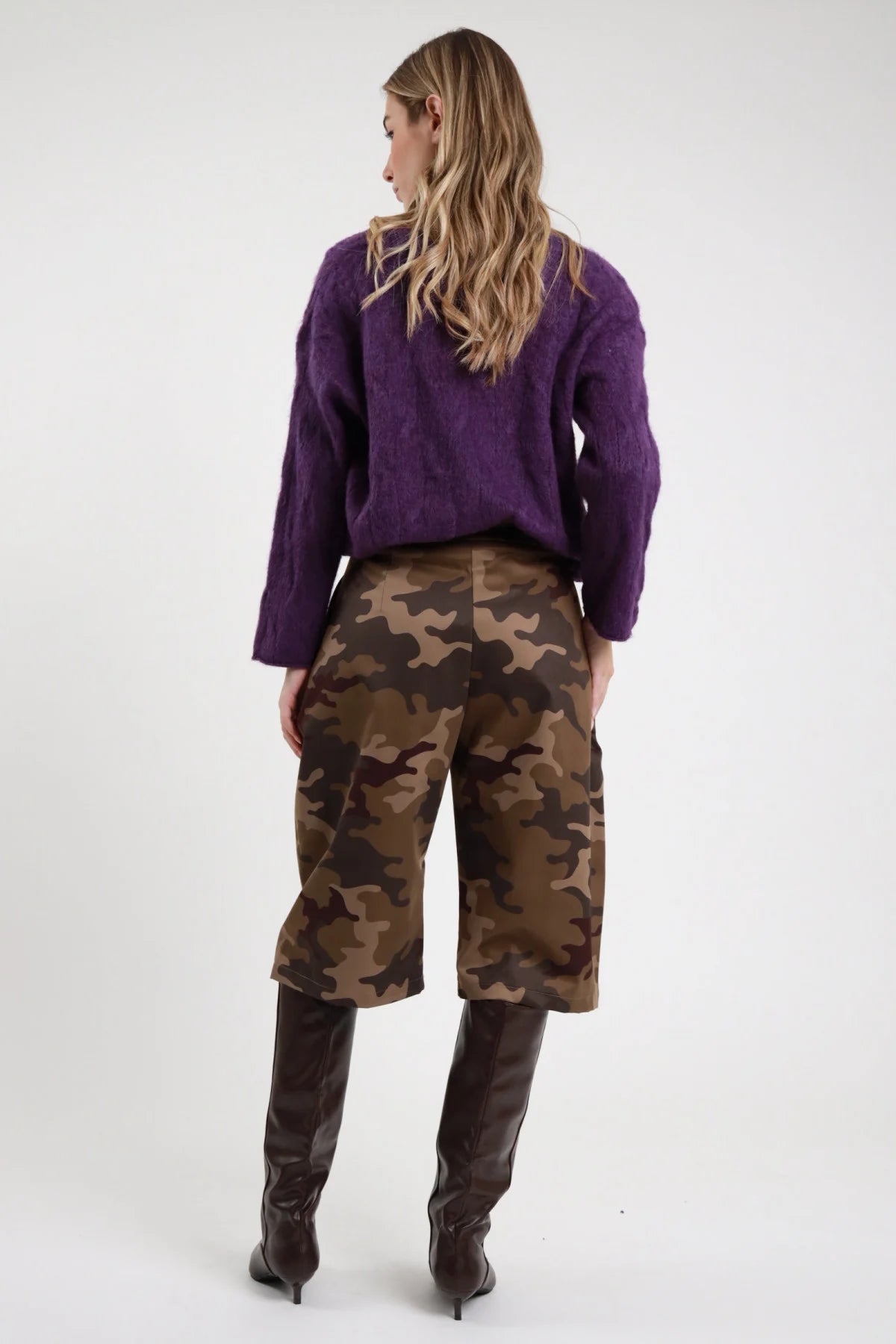 Bermuda camouflage Susy Mix Pre-Fall stampa mimetica militare khaki marrone verde oliva vita alta gamba larga wide retro liscio posteriore intera - modella posteriore intera capelli biondi mossi sfondo bianco maglione viola trecce stivali cuissardes marrone abbinati
