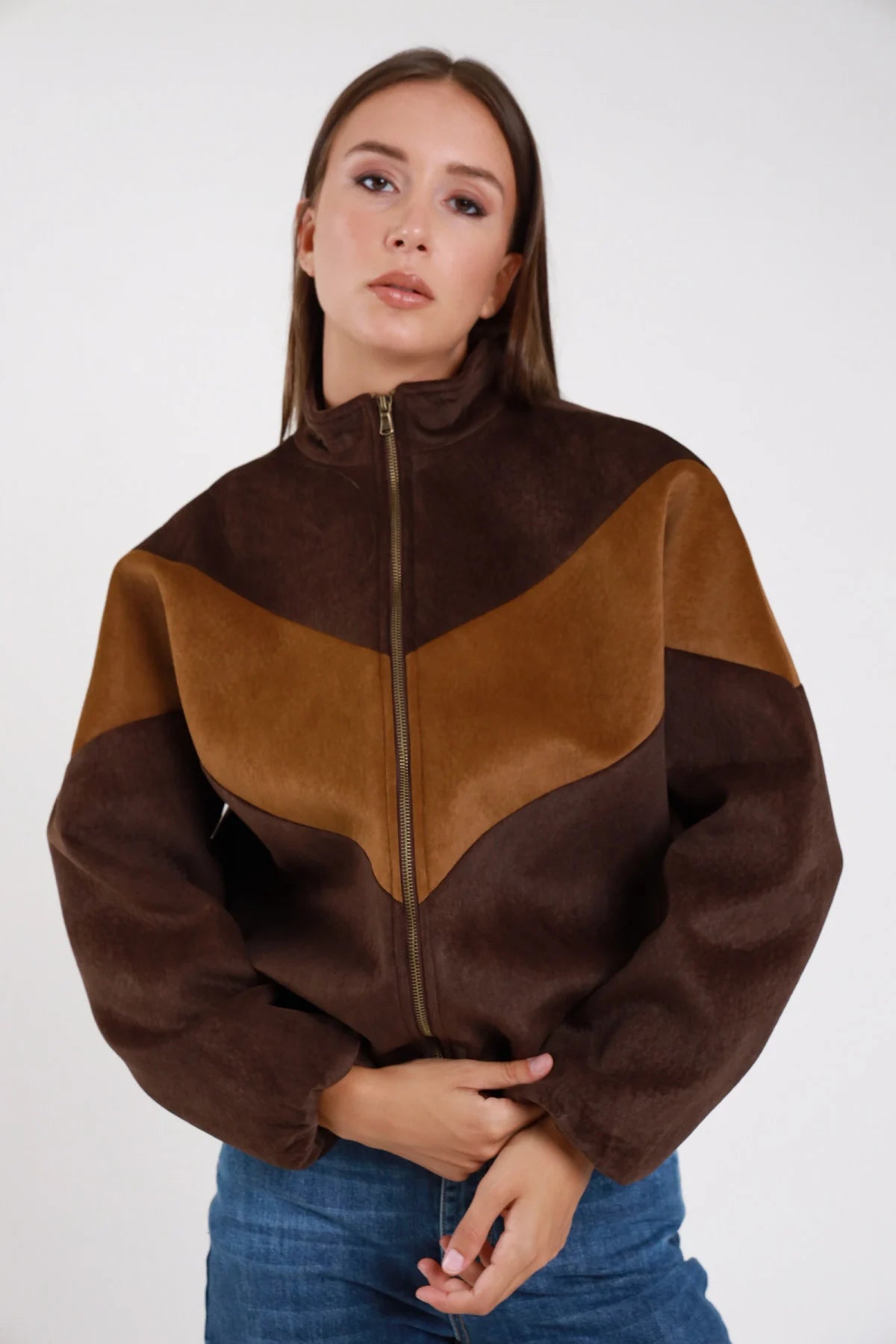 Bomber bicolor flock cioccolato camel chevron seduta dinamica maniche balloon polsino elastico - modella seduta tre quarti sguardo laterale jeans blu capelli castani lisci