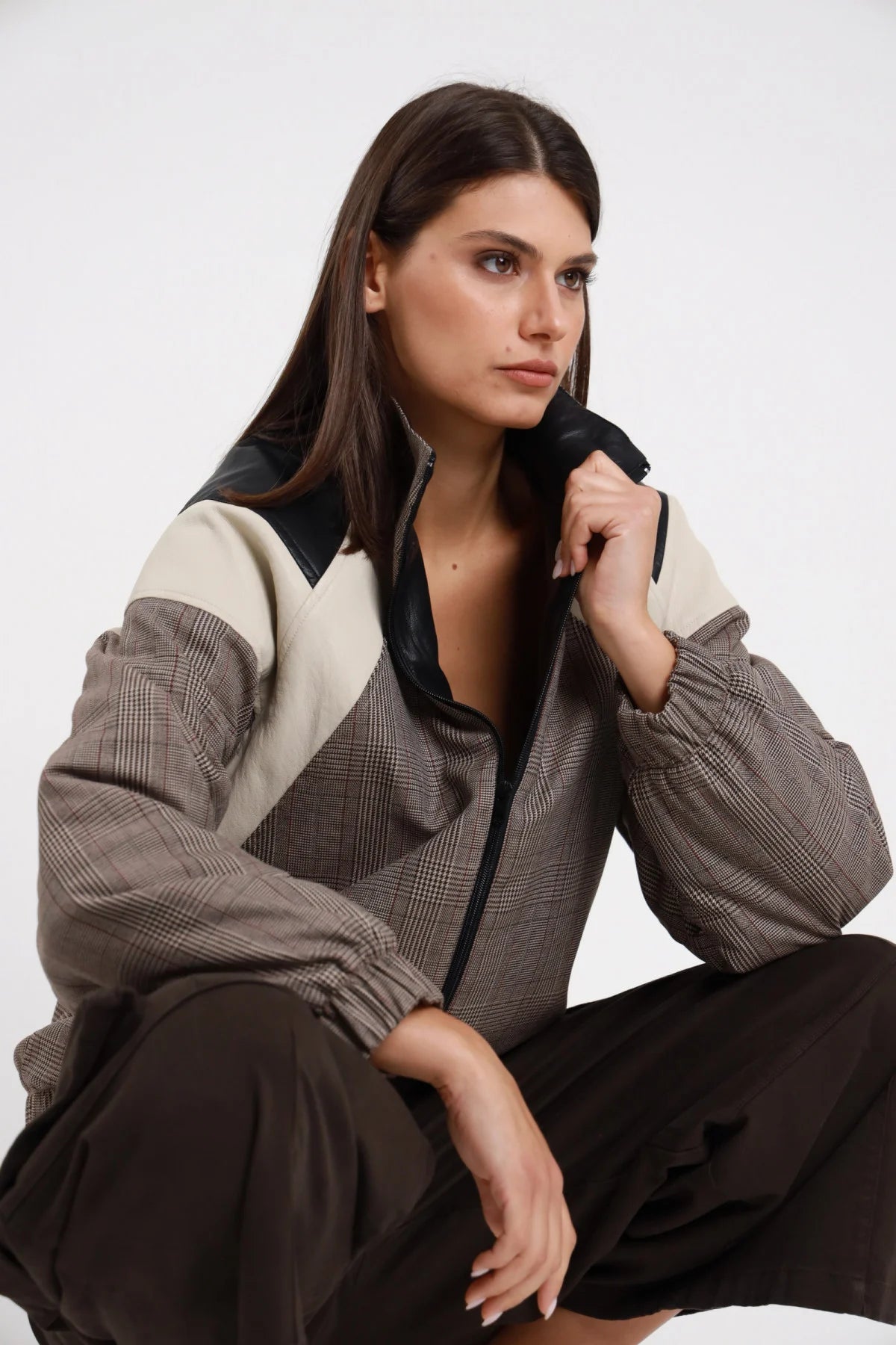 Bomber Check Ecopelle color block check Prince of Wales colletto ecopelle nera pannello panna chevron zip aperta V manica balloon polsino elastico dettaglio busto seduta posa dinamica - modella busto 3/4 frontale seduta posa dinamica sguardo frontale intenso capelli castani scuri lisci sfondo bianco bermuda tasconi cioccolato abbinato