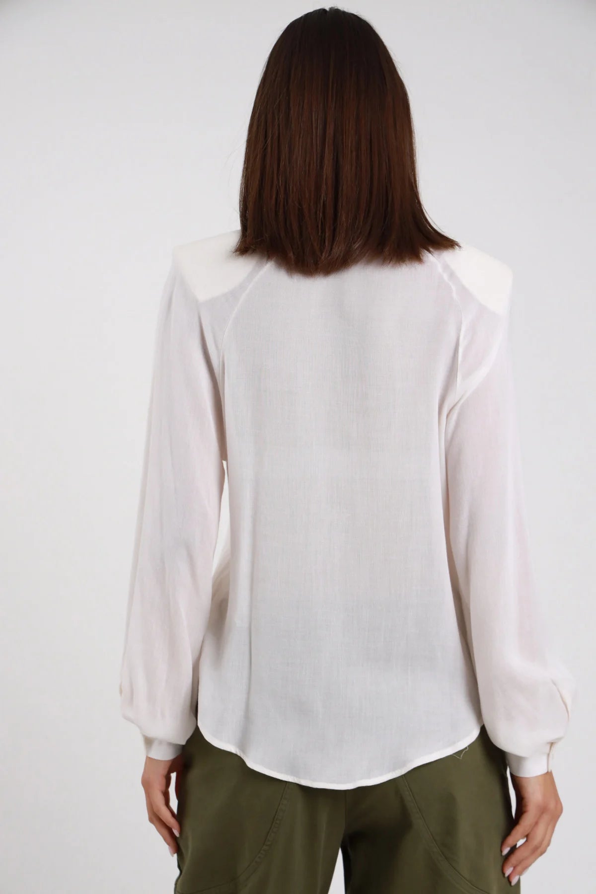 Camicia Fiocco Lana bianco panna silhouette loose fluida semitrasparente manica balloon polsino elastico retro intera schiena - modella retro intera capelli castani lisci sfondo bianco pantaloni verde militare