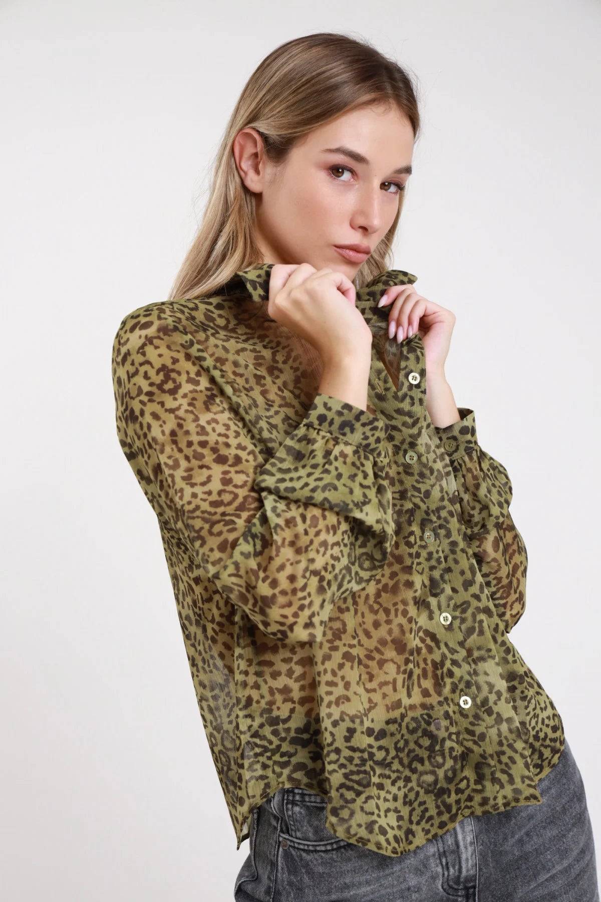 Camicia animalier leopard verde militare chiffon - modella busto laterale mani al colletto sguardo obliquo con jeans grigio