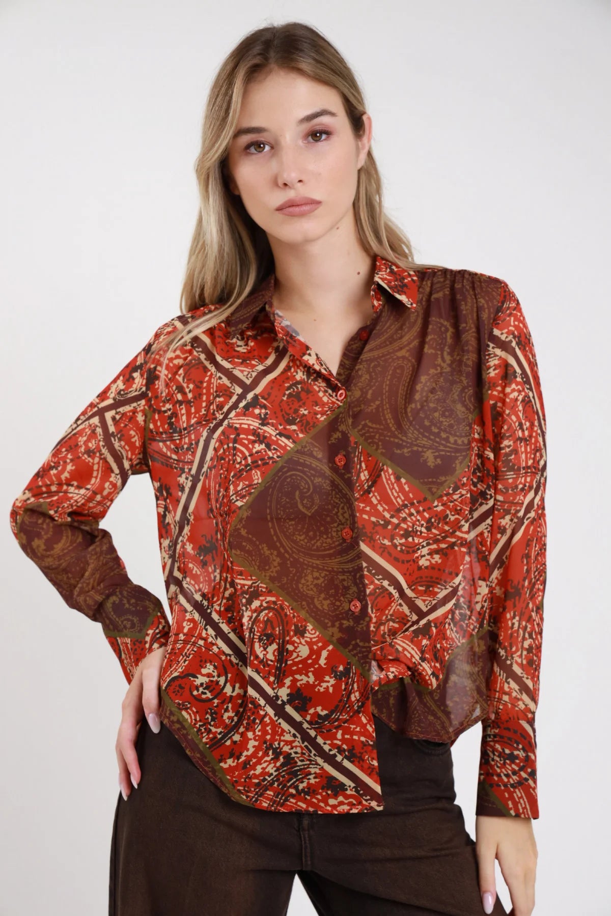 Camicia fantasia paisley cachemire rosso borgogna cioccolato retro intera manica lunga polsino orlo curvo - modella retro intera mani laterali sguardo posteriore pantaloni marrone scuro capelli biondi ondulati lunghi