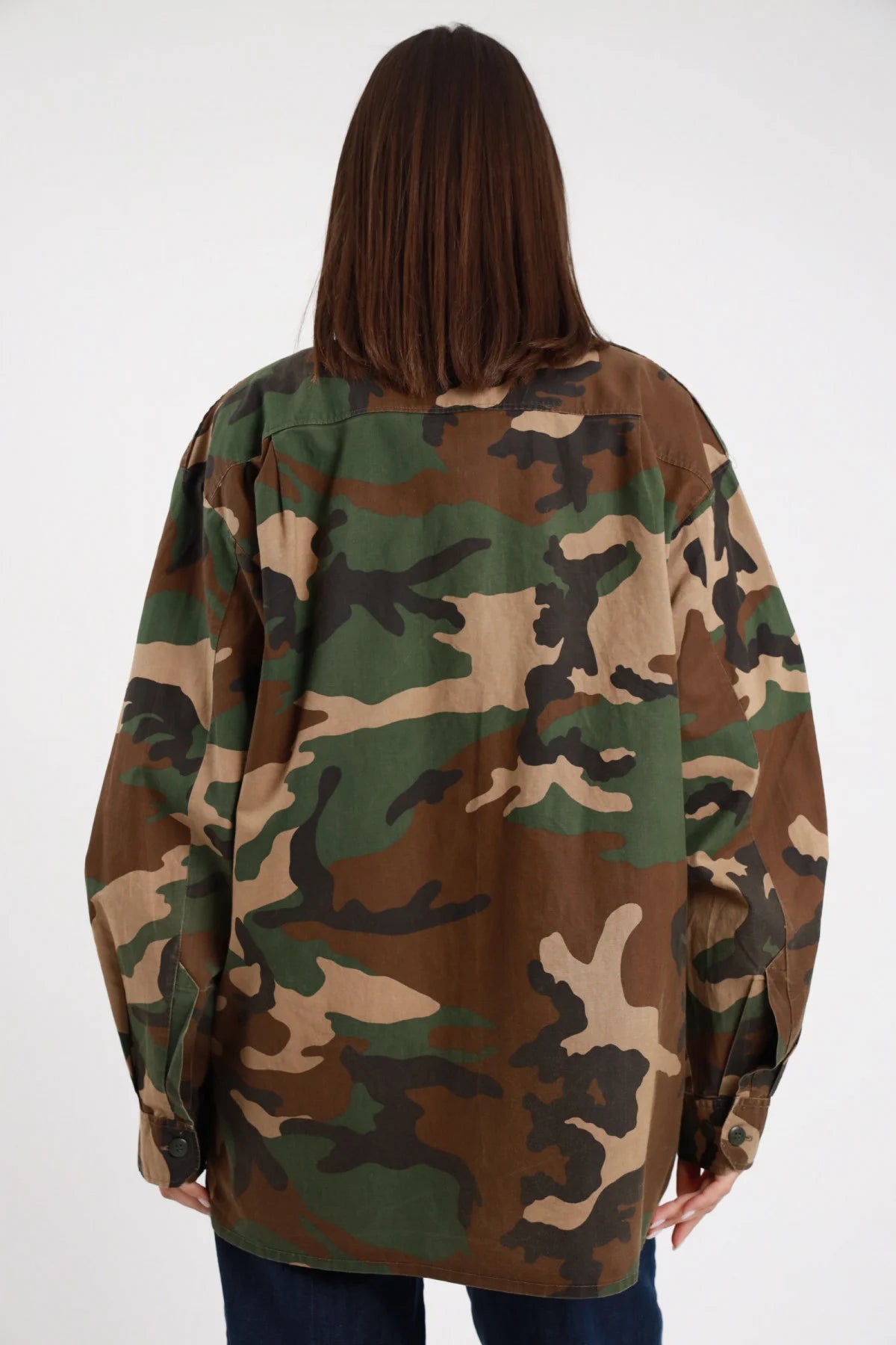 Camicia Militare Mimetica Woodland Borchie Strass 95% cotone retro liscio mimetico senza applicazioni silhouette oversize lunga maxi posteriore manica lunga ampia - modella intera posteriore posa statica capelli castani lisci sfondo bianco jeans denim scuro