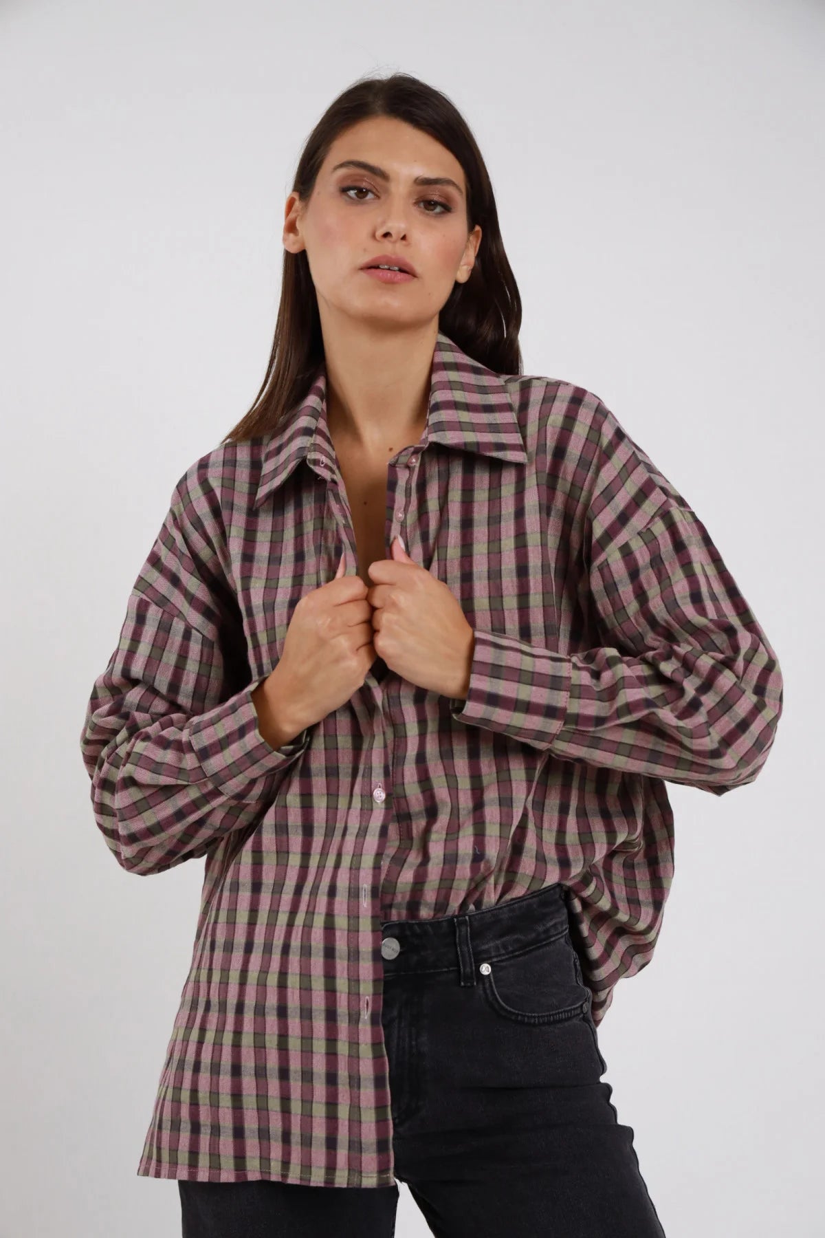 Camicia Quadri gingham malva rosato grigio antracite beige oversize drop shoulder balloon colletto classico silhouette loose lunga busto frontale 3/4 mani colletto aperta sguardo laterale - modella busto frontale 3/4 mani colletto aperta sguardo laterale capelli castani lisci sfondo bianco jeans neri scuri