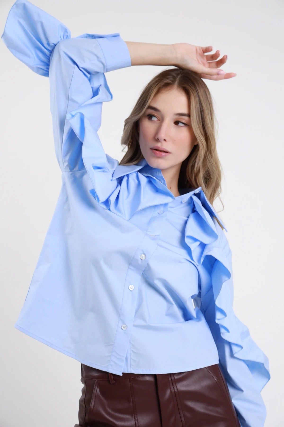 Camicia Rouches bianco ottico 100% cotone popeline colletto punte bottoni bianchi ruches volant multipli verticali cascata spalla destra manica lunga polsino ruches oversize boxy frontale intera mano fianco - modella intera frontale mano fianco sguardo frontale capelli biondi lisci sfondo bianco jeans antracite abbinati