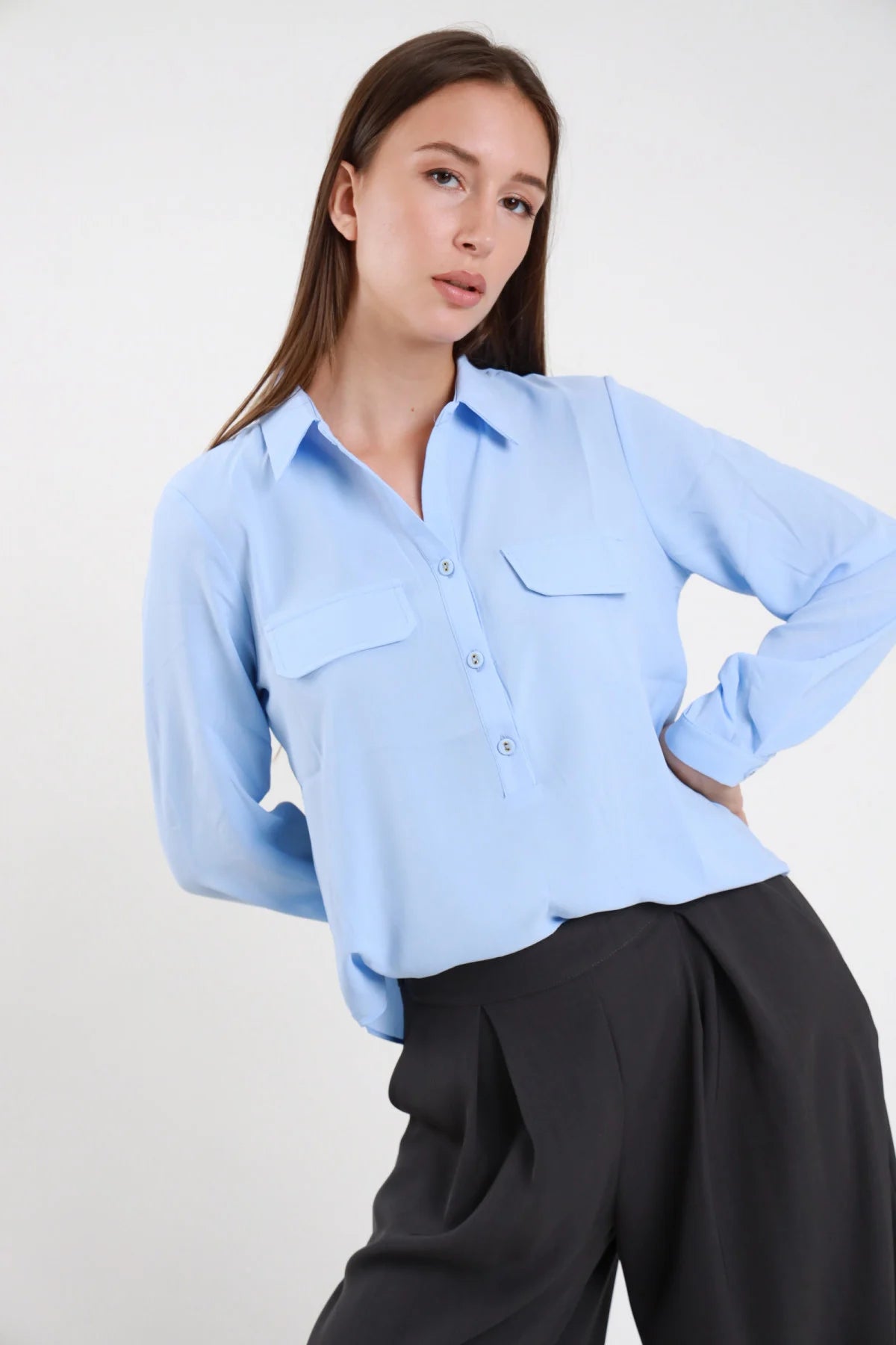 Camicia serafino bianca con taschini con patta e bottoni dorati abbinata a jeans neri - vista frontale